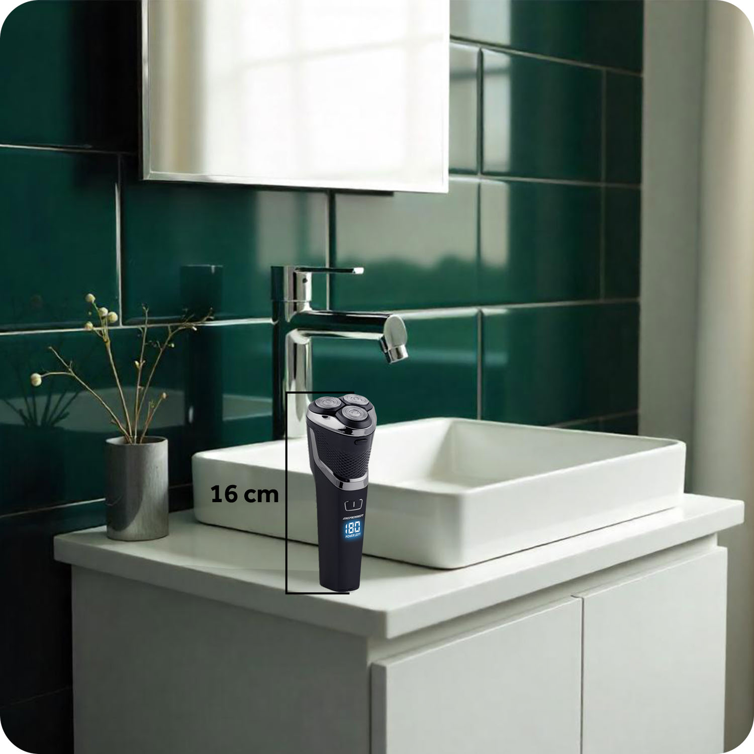 Elektryczna golarka stoi na białej szafce w łazience. W tle biała umywalka, kran i zielona kafelkowa ściana.