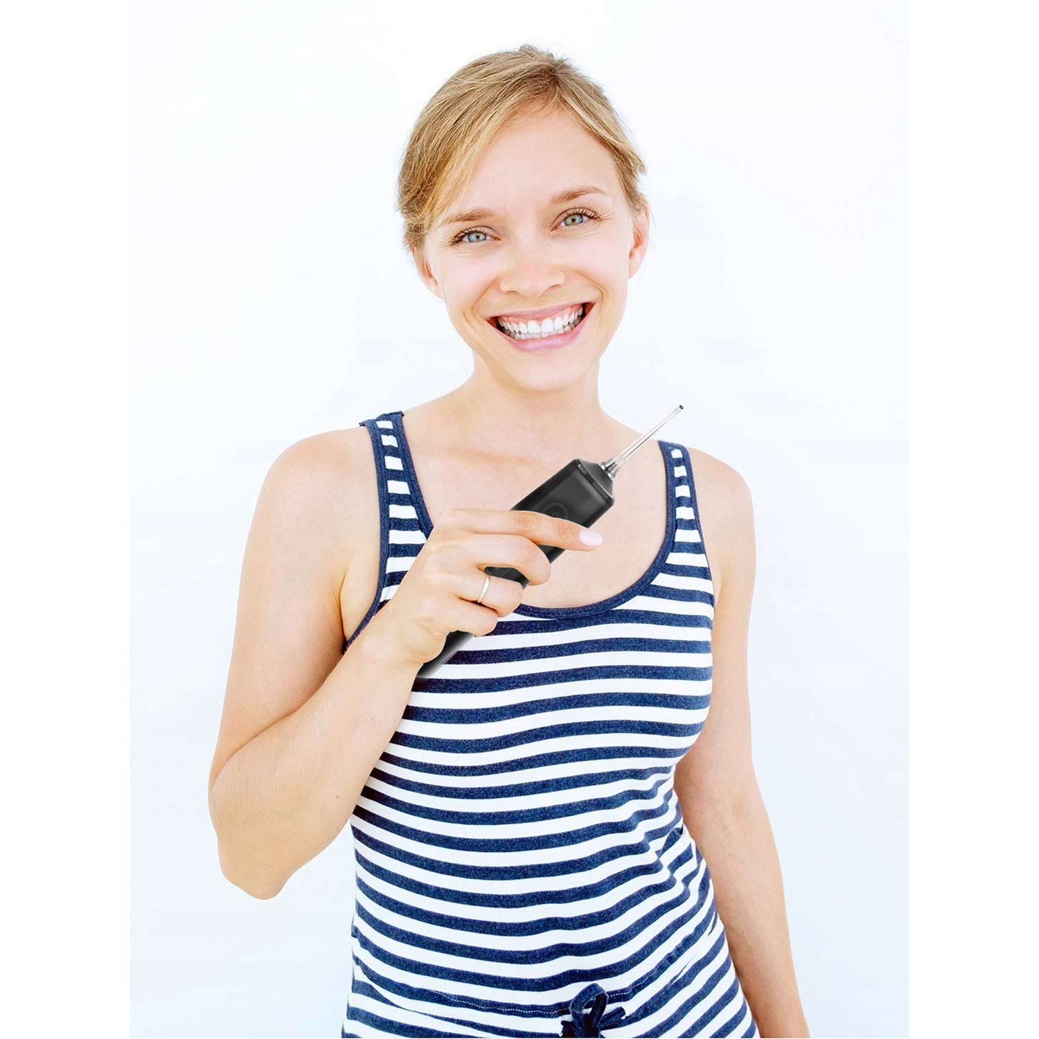 Uśmiechnięta blondynka trzyma czarne urządzenie. Ma na sobie pasiasty top na białym tle.