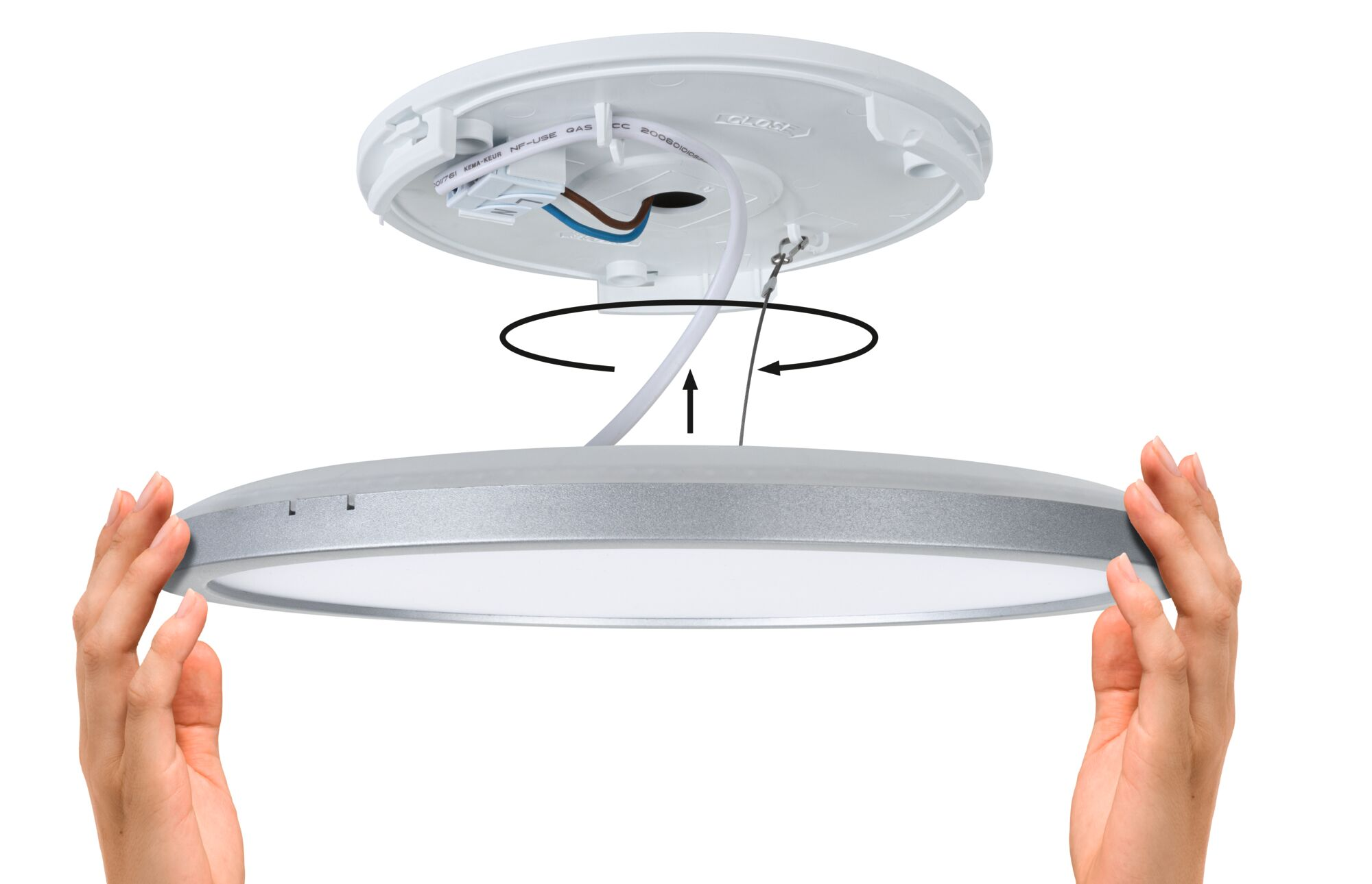 Ręce trzymają okrągłą lampę sufitową LED, z białą podstawą i srebrną obwódką. Strzałki wskazują proces instalacji.