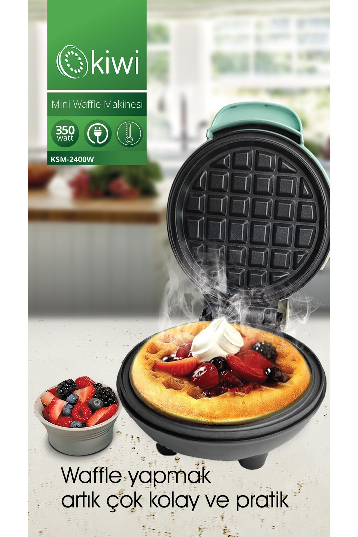 Üzerinde meyve ve krema bulunan pişmiş bir waffle ile waffle makinesi. Yanında bir kase meyve duruyor. Yeşil ve siyah renkler.