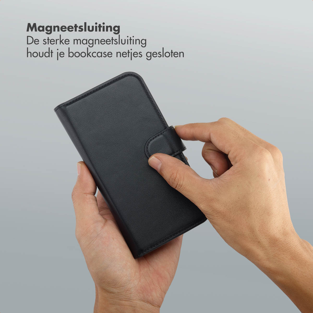 Een hand houdt een zwarte telefoonhoes vast. De hoes heeft een magnetische sluiting. De tekst bovenaan zegt magnetische sluiting.