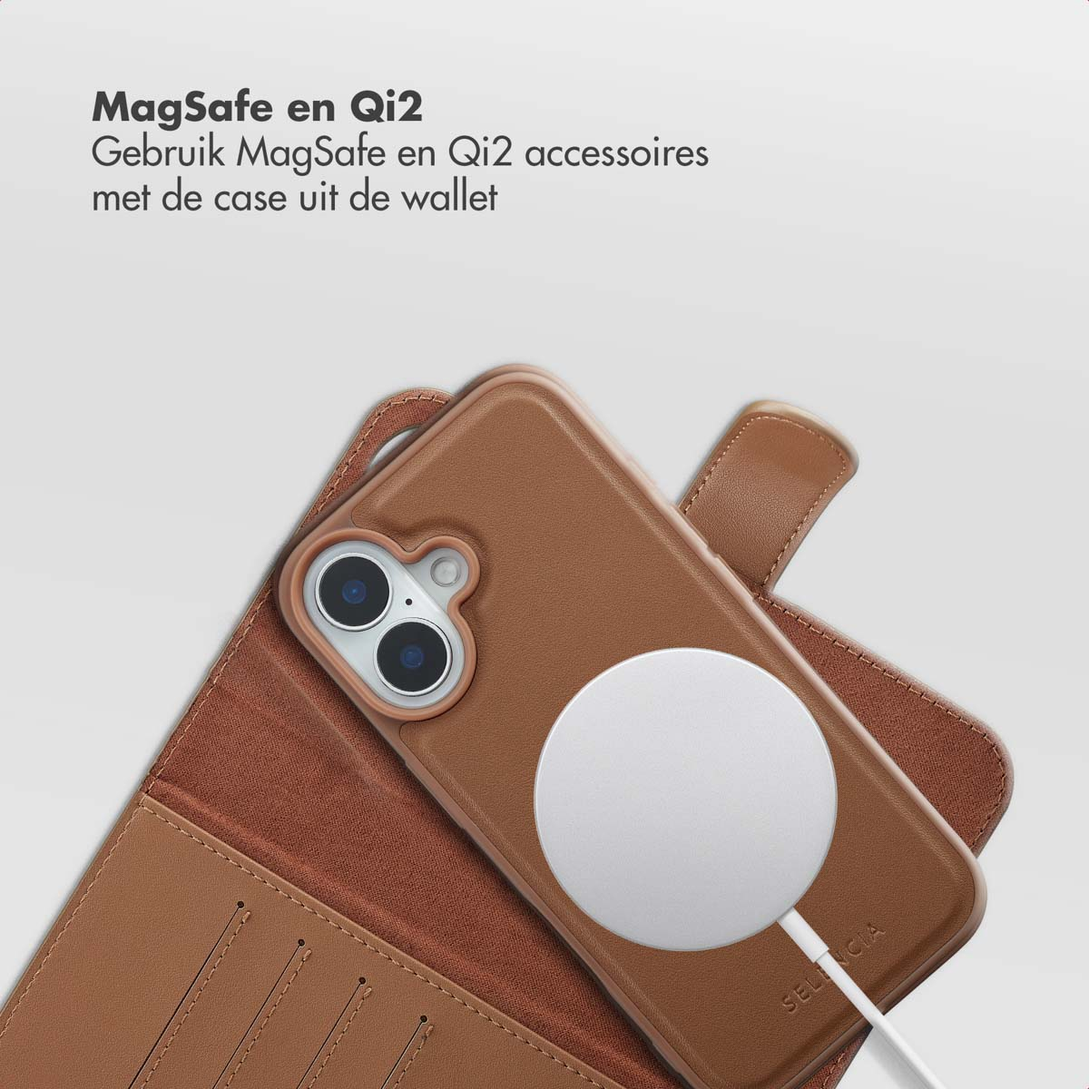 Een bruine telefoonhoes met een witte oplaadpad ligt op een bruine portemonnee. De telefoon heeft twee camera's. Tekst: MagSafe en Qi2.