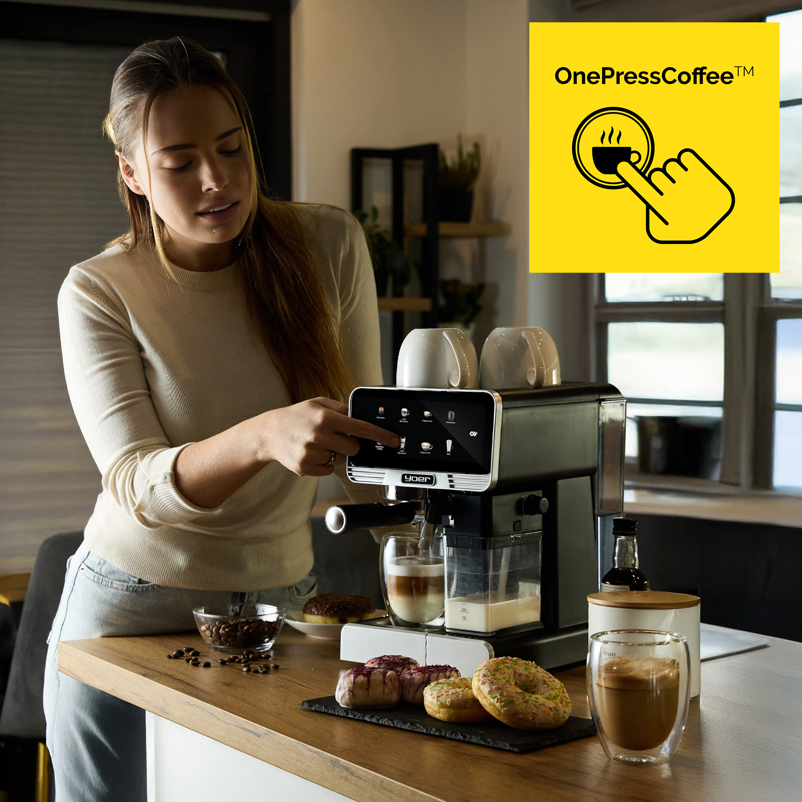 Kobieta robi kawę z ekspresu. Pączki i filiżanki do kawy na stole. Żółty kwadrat z logo.