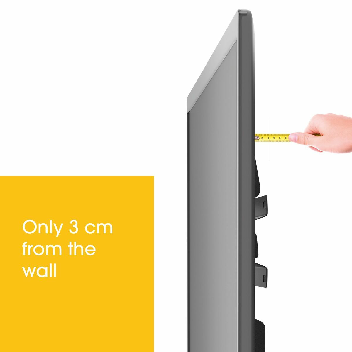 Se mide un televisor con una cinta métrica. El texto dice, 'Sólo 3 cm de la pared' sobre un fondo amarillo.