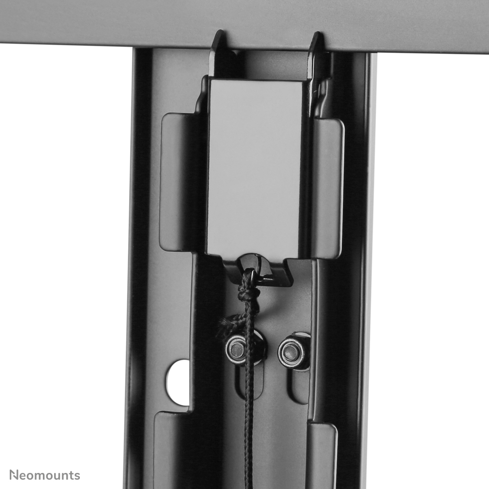 Close-up of a black metal bracket with a white rectangular plate attached. A black string hangs down, with two bolts visible below.