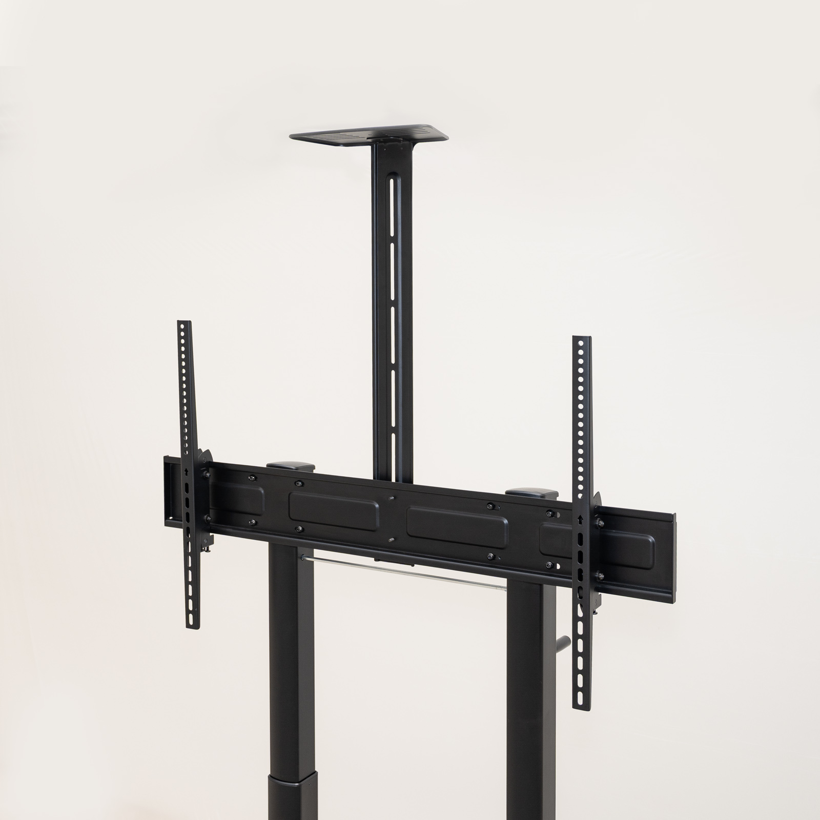 Soporte de TV negro contra pared blanca. Cuenta con un poste vertical con soportes horizontales y dos soportes laterales.