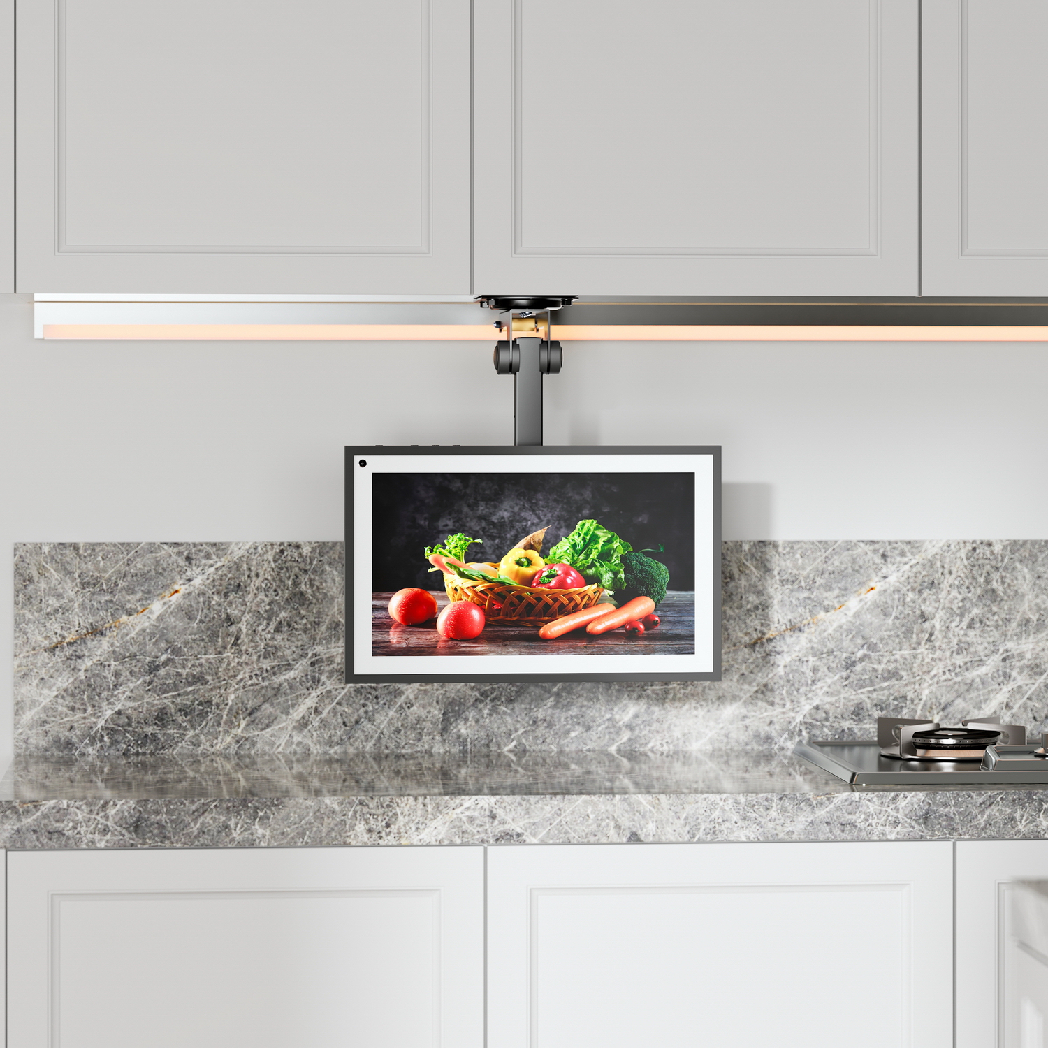 Cucina con schermo che mostra verdure. Sono visibili anche armadi, piano di lavoro e piano cottura.