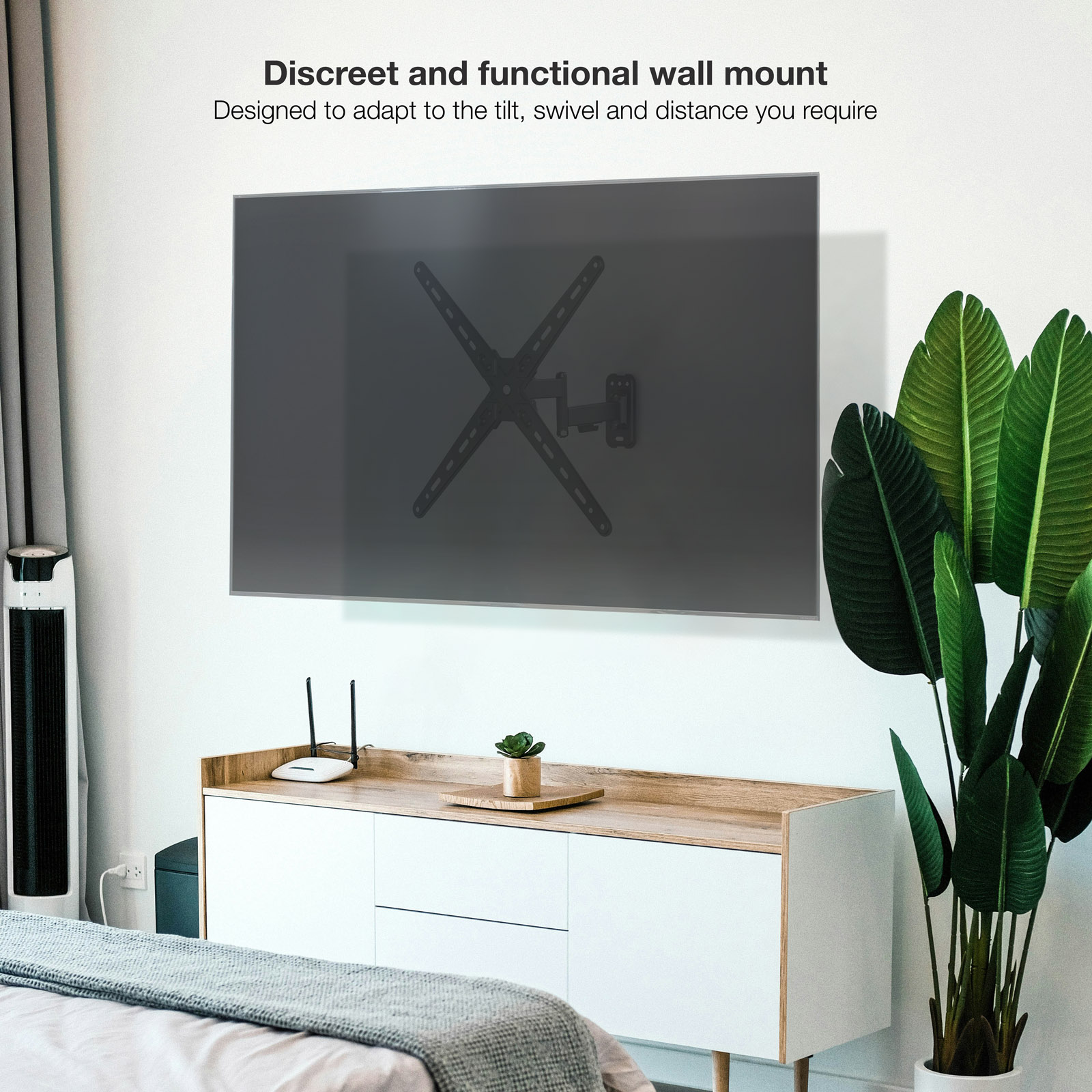 Un televisor montado en una pared blanca. Una planta, un gabinete y una cama están en la habitación. El soporte del televisor es visible.