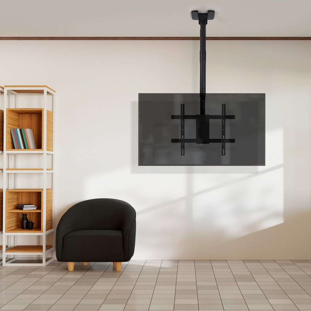 Un soporte de TV negro está suspendido del techo. Un sillón negro está en un suelo embaldosado. Una estantería está a la izquierda.
