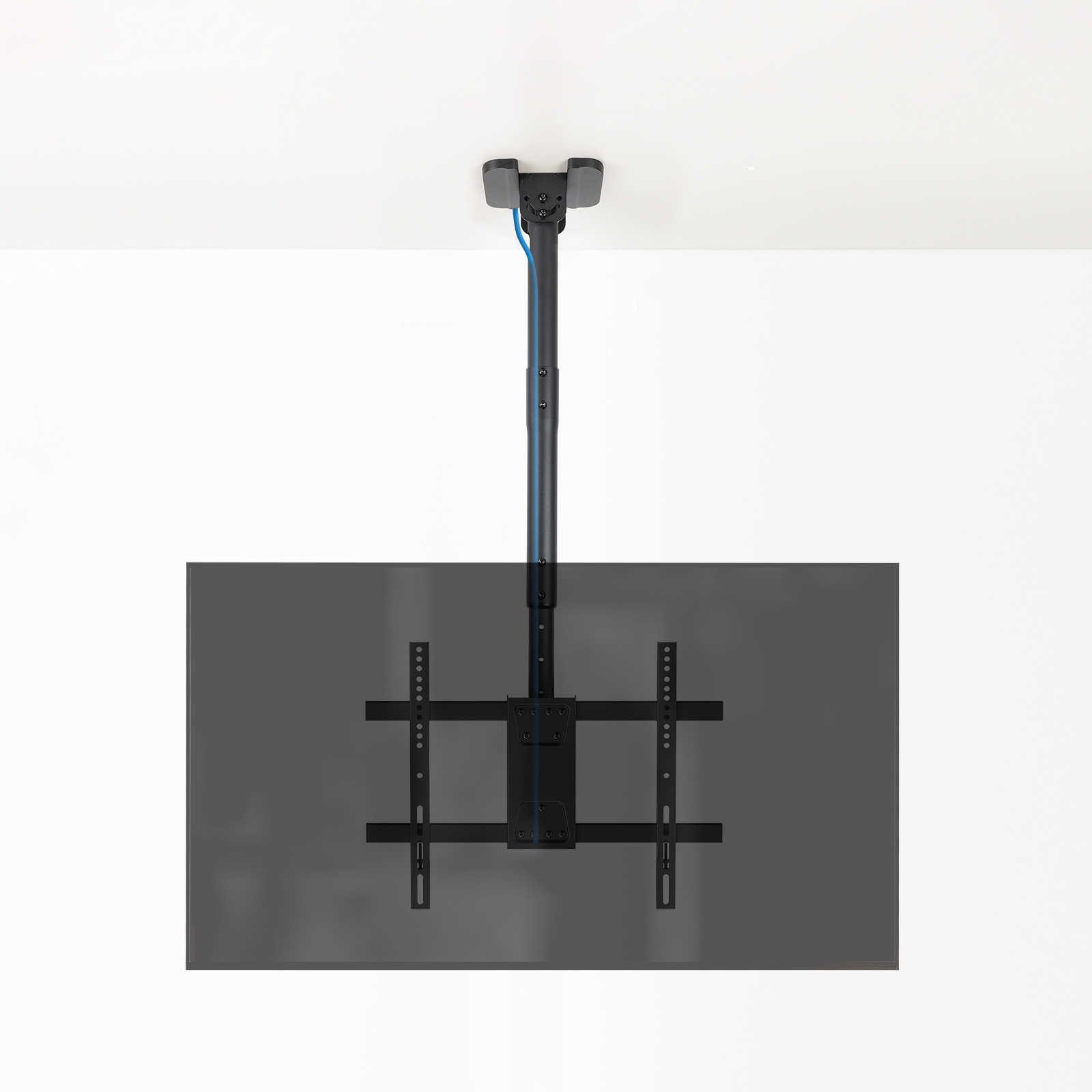 Un soporte de TV montado en el techo. Soporte negro y poste de soporte contra un techo blanco y una pantalla gris.