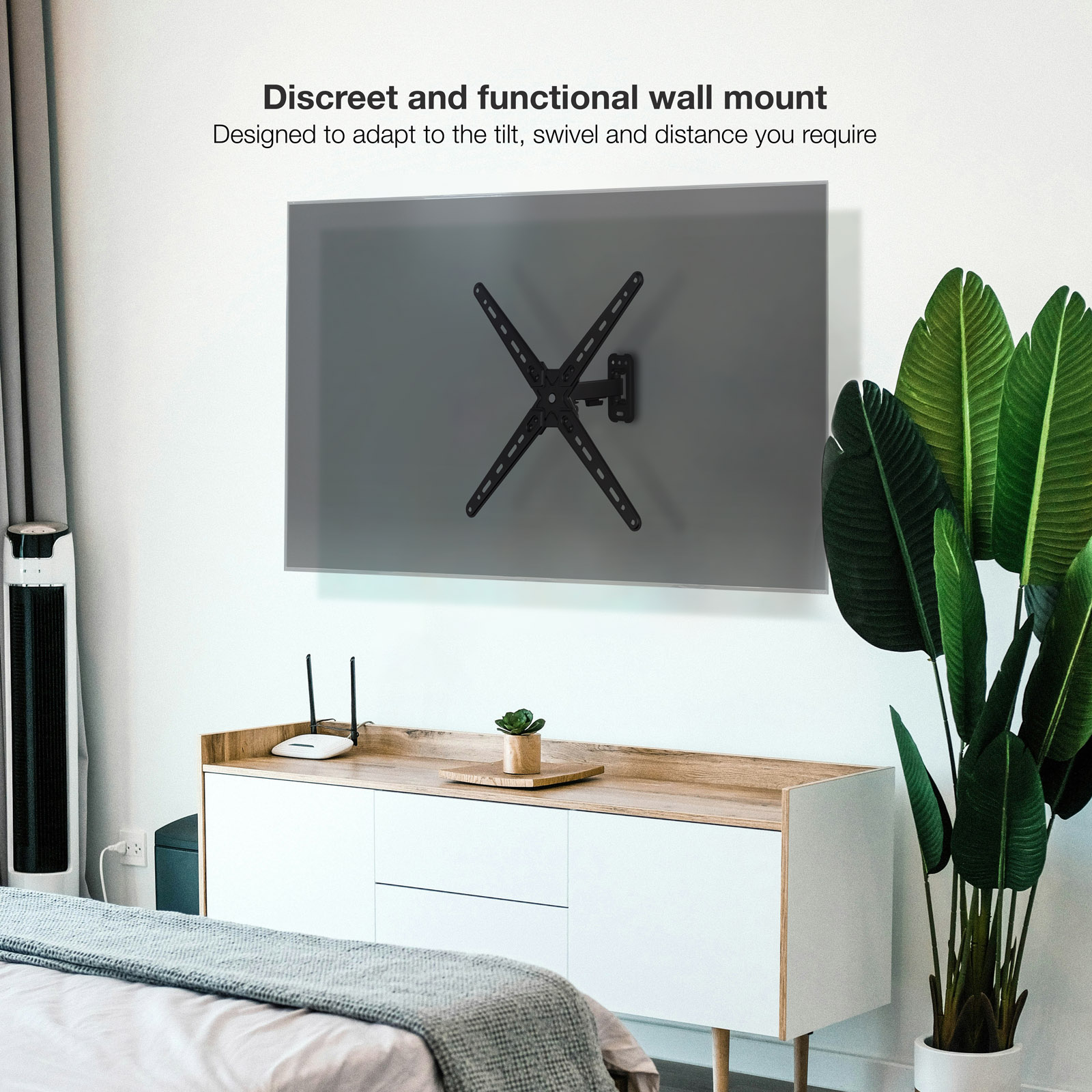 Un soporte de pared para TV negro está en una pantalla gris. A la derecha hay una planta verde. Debajo de la pantalla hay un gabinete blanco.