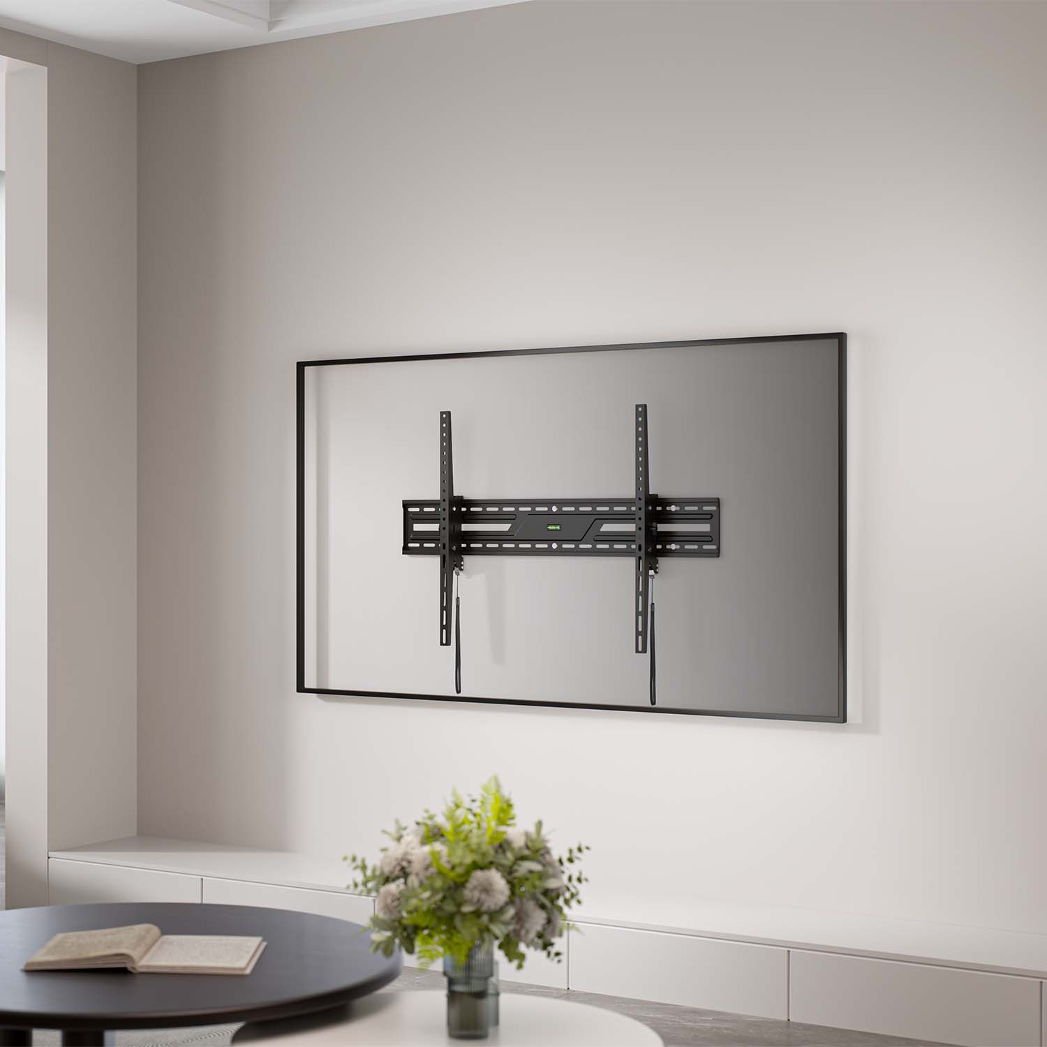Un televisor está montado en una pared blanca. Un soporte negro está sujeto al televisor. Una mesa y un florero están en primer plano.
