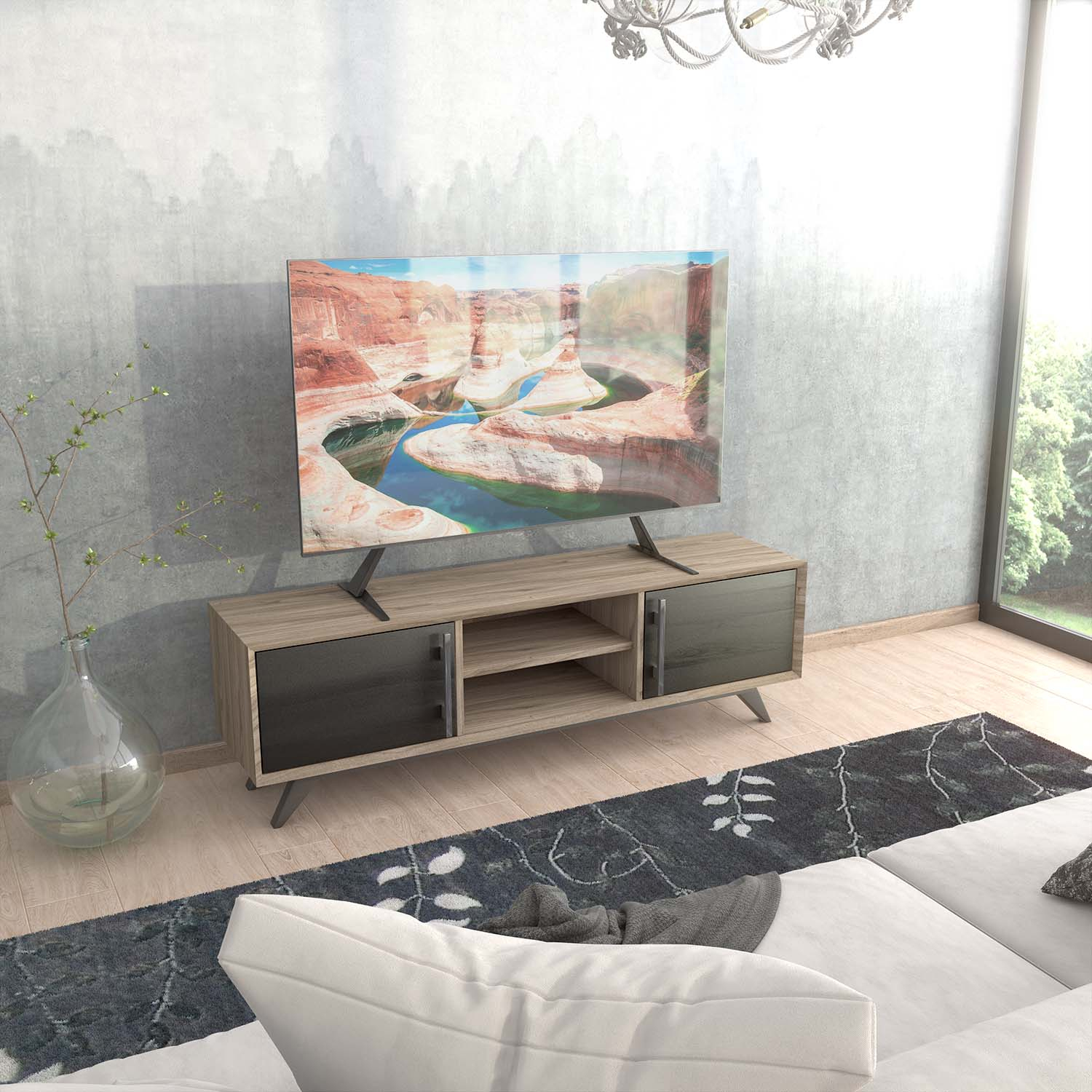 Una TV mostra un canyon. È su un mobile in legno. Un tappeto e un divano sono di fronte. Un lampadario è appeso al soffitto.
