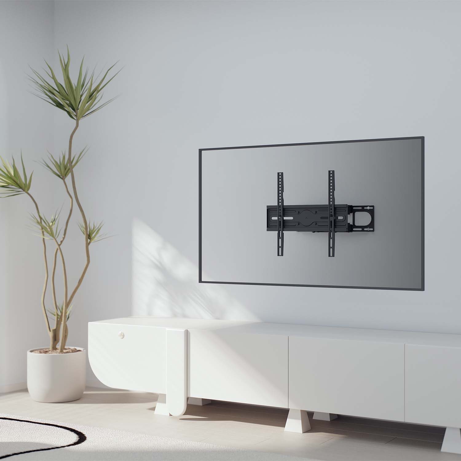 Un soporte de TV está en una pared blanca. Un televisor está montado en él. Abajo hay un armario blanco y una planta. El suelo es blanco.