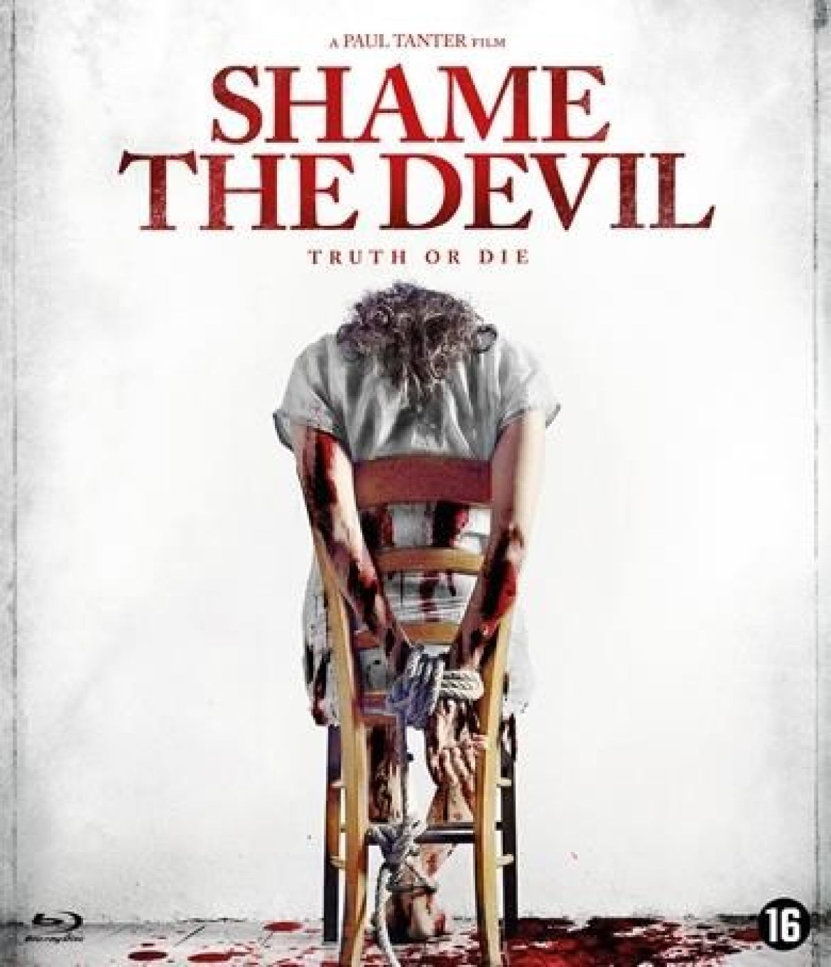 Affiche de film. Une personne est attachée à une chaise, bras ensanglantés. Le titre est 'Shame The Devil'. Du sang sur le sol et une classification '16'.