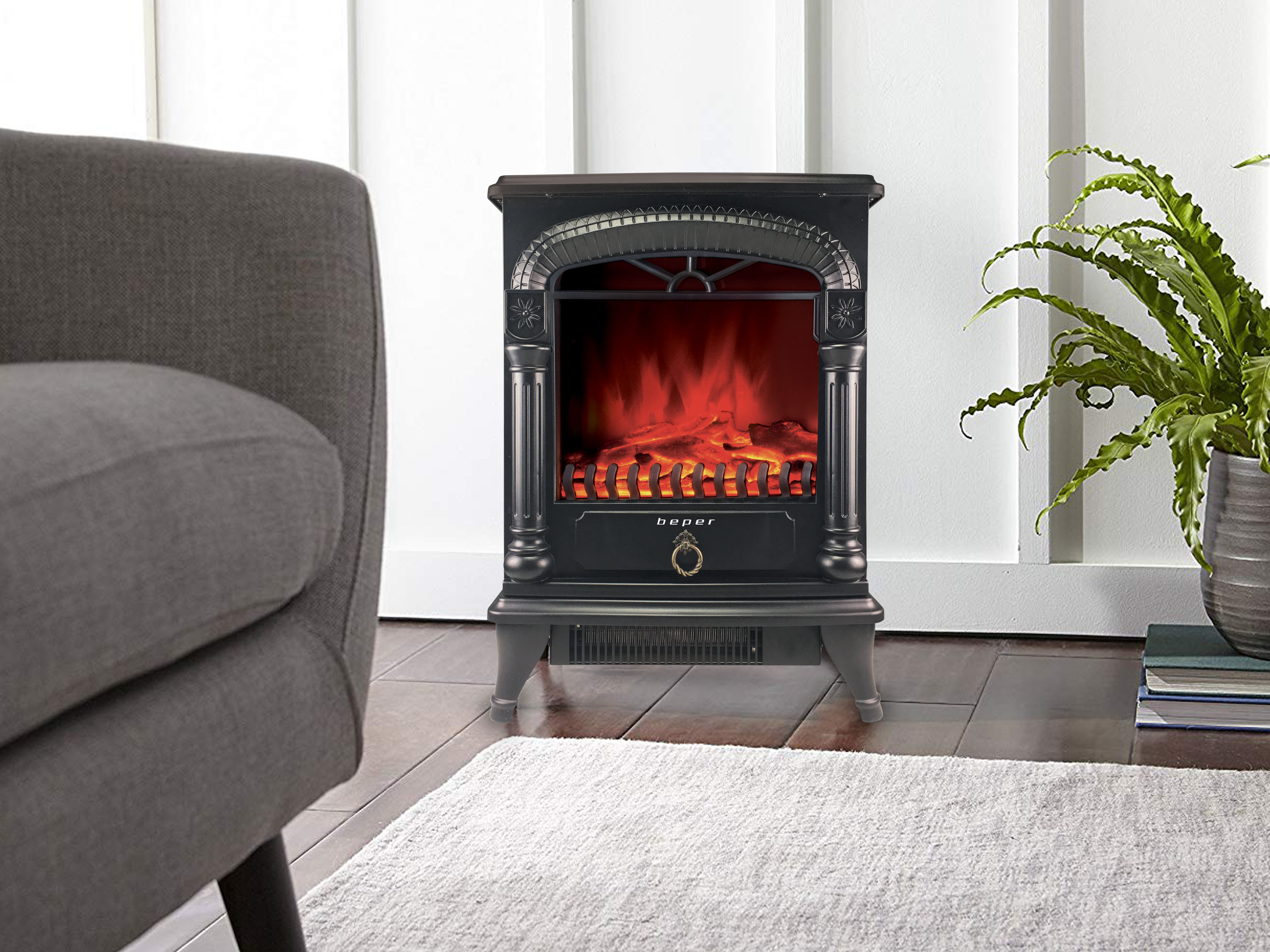 Un caminetto elettrico nero con fiamme rosse, una poltrona, una felce e un tappeto sono in una stanza.
