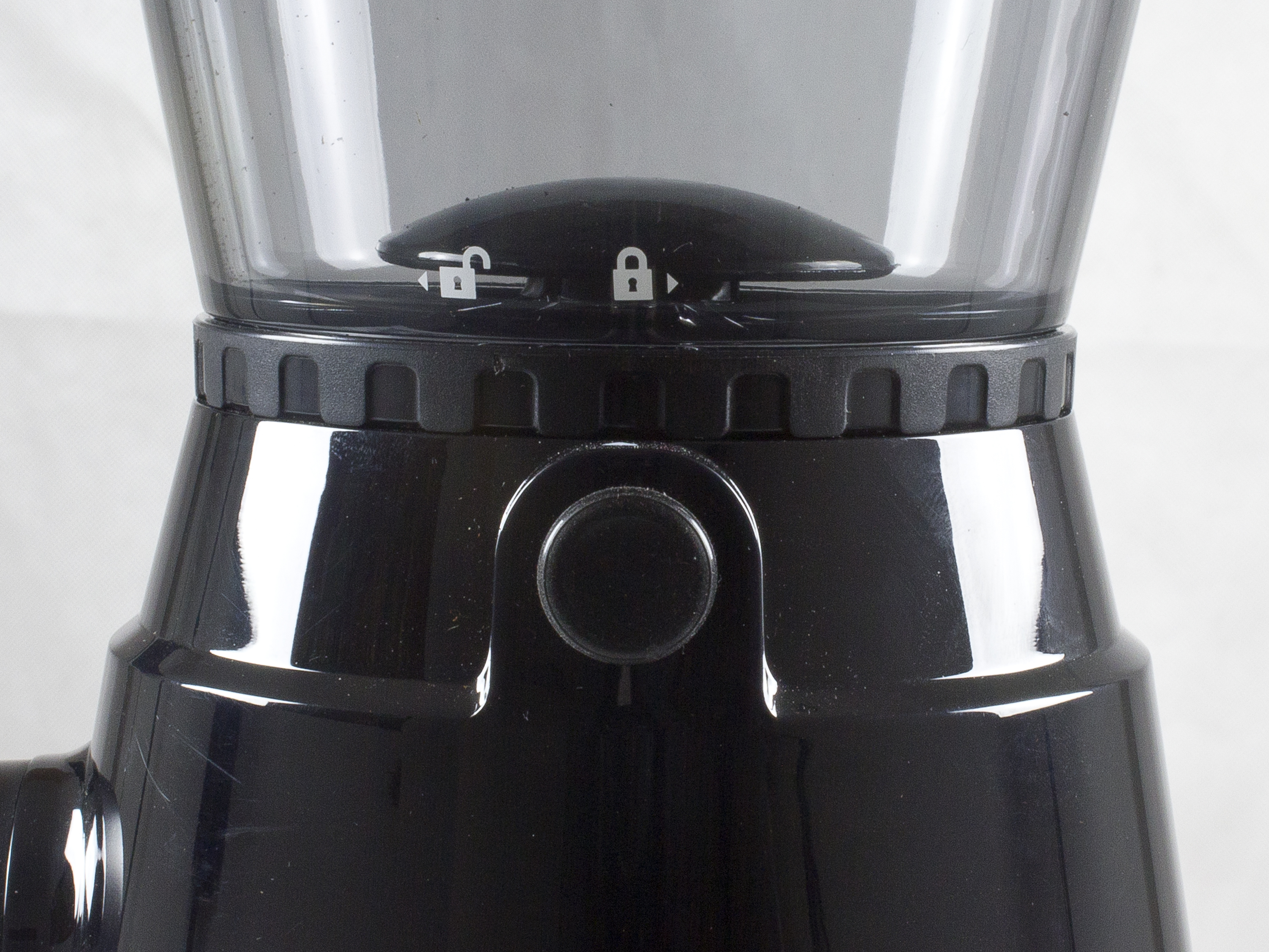 Primo piano di un macinacaffè nero. Ha una parte superiore trasparente e una base nera con un pulsante.