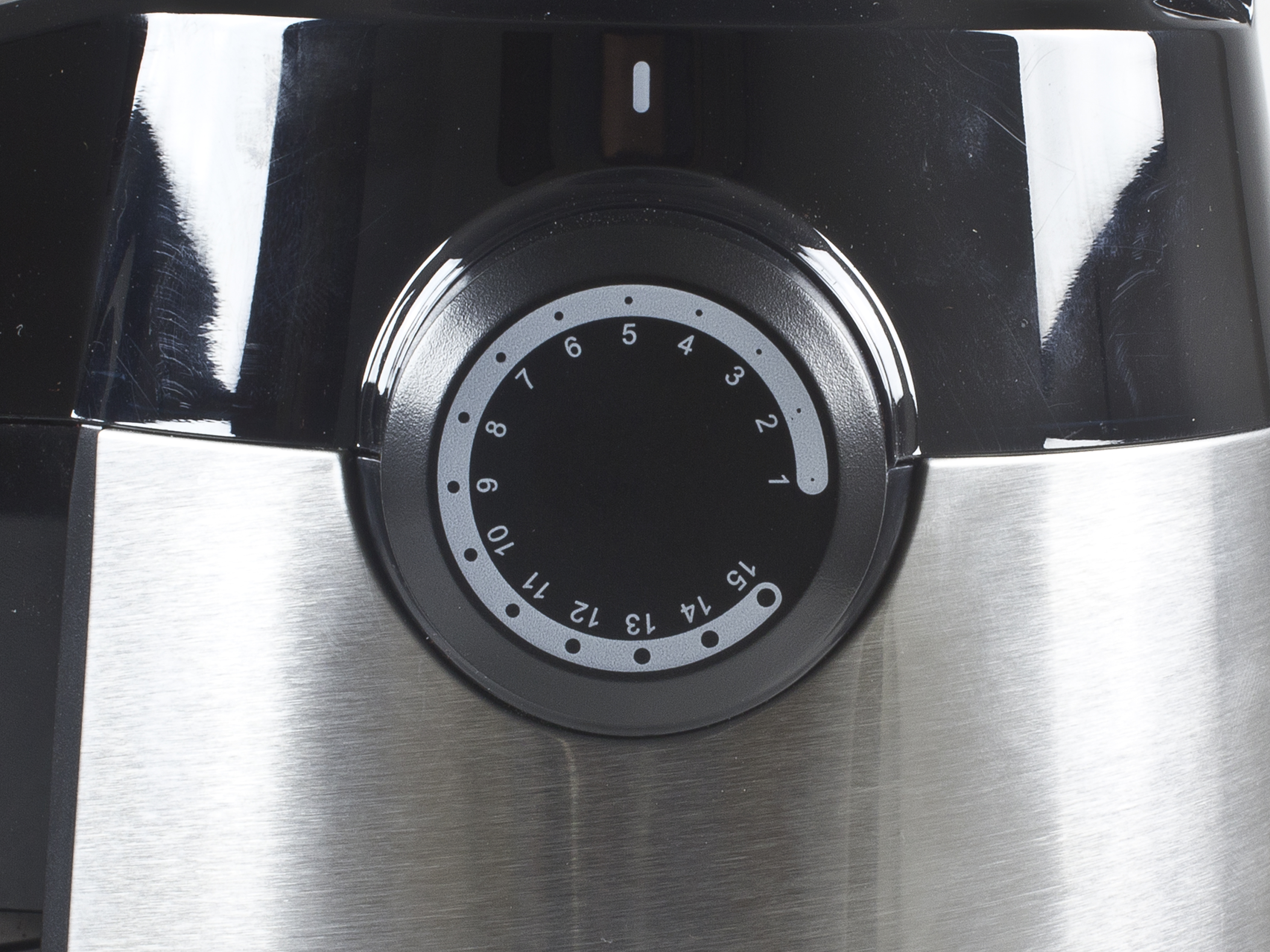 Primo piano di un quadrante nero con numeri da 1 a 15 e un indicatore bianco. È su un elettrodomestico nero metallico.