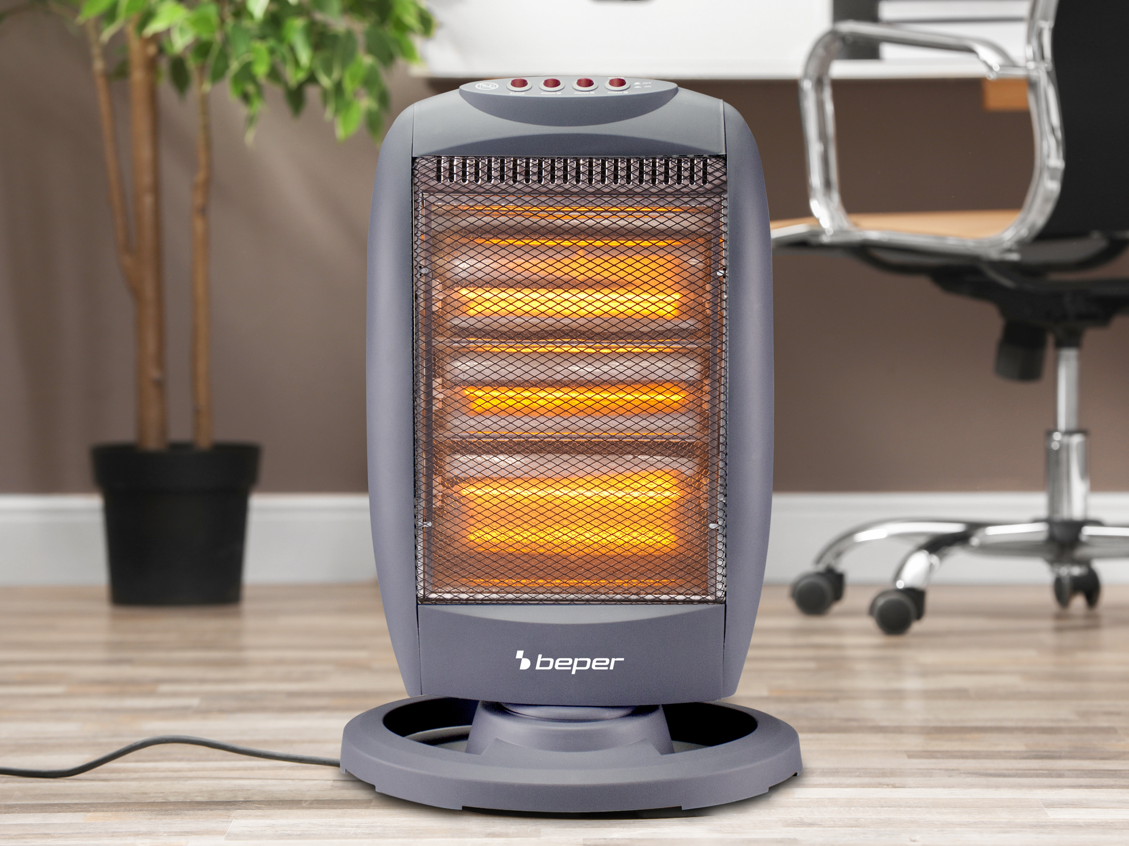 Un termoventilatore grigio con elemento incandescente è su un pavimento in legno. Una pianta e una sedia sullo sfondo.