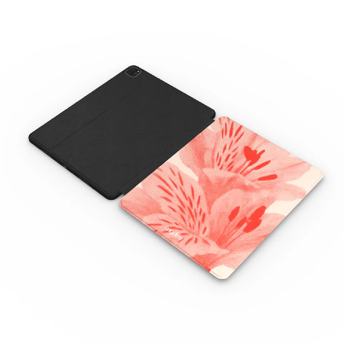 Tablet nero accanto a una cover a fantasia floreale. La cover ha fiori rossi e rosa.