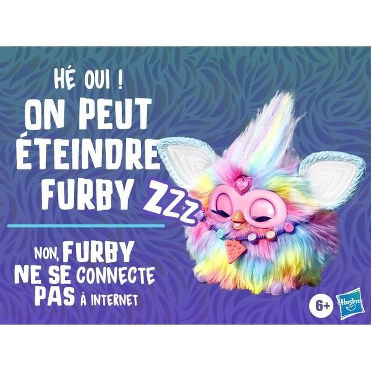 Kolorowa zabawka Furby z zamkniętymi oczami znajduje się w centrum. Tekst mówi: 'Możesz wyłączyć Furby' i 'Furby nie łączy się z internetem'.