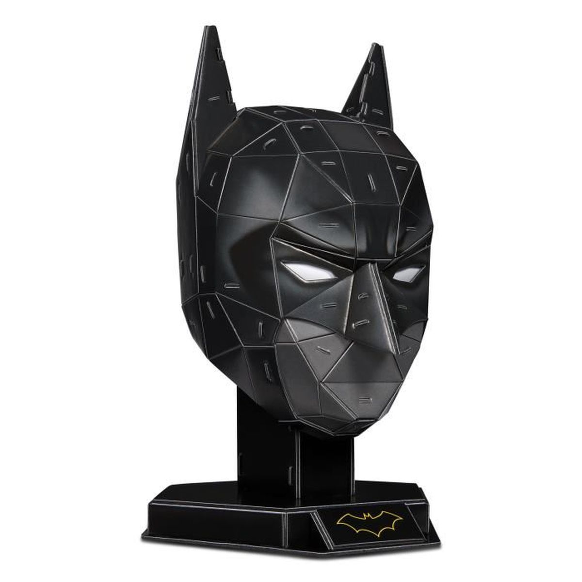 Una scultura a forma di testa di Batman geometrica nera. Ha un supporto. Gli occhi sono bianchi. Un simbolo di pipistrello dorato sulla base.
