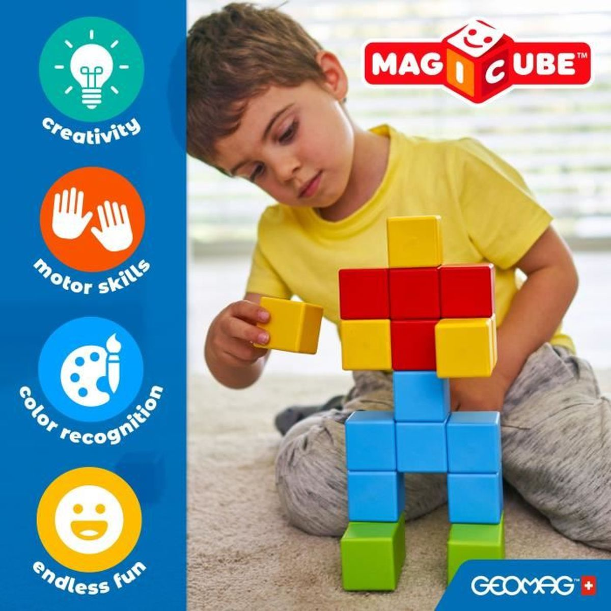 Un enfant construit une structure avec des blocs magnétiques colorés. Les blocs sont rouges, jaunes, bleus et verts. Le logo MAG CUBE est visible.