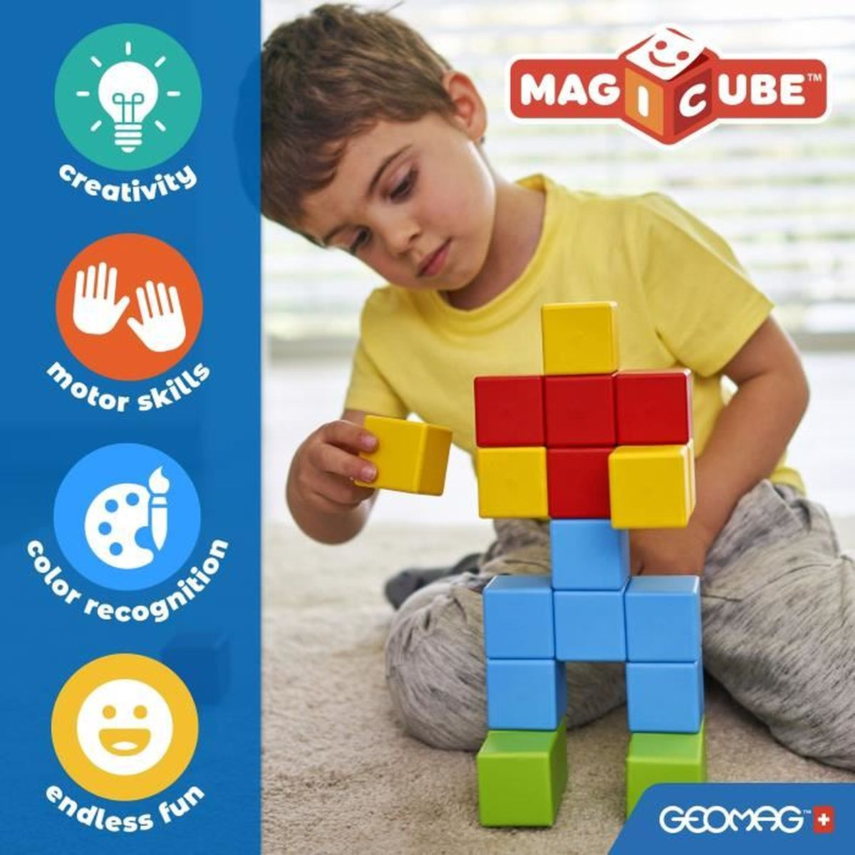 Dziecko buduje z kolorowych klocków. Klocki są czerwone, żółte, niebieskie i zielone. Logo 'MAG CUBE' znajduje się w prawym górnym rogu.