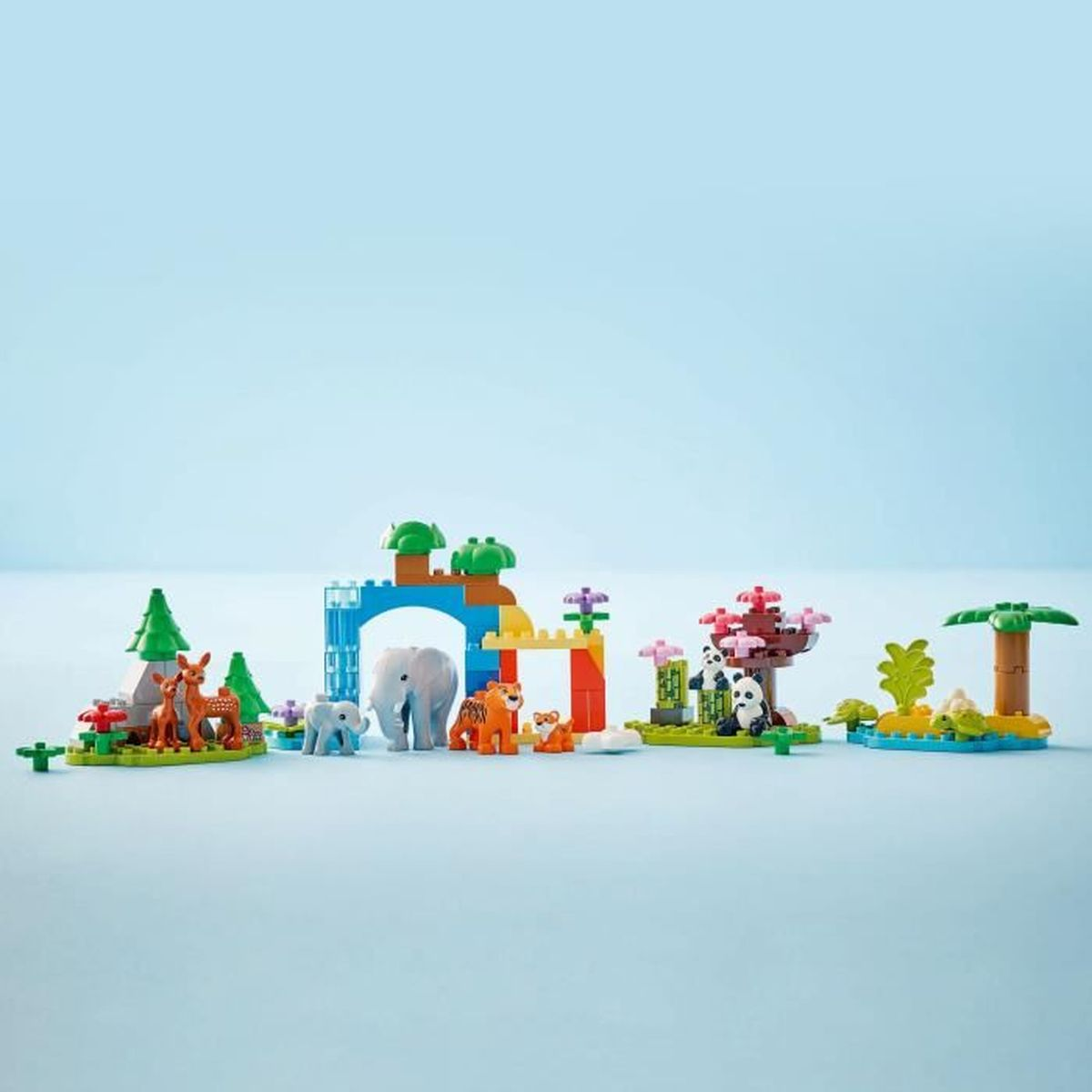 Ein farbenfrohes Spielzeugset mit Tierfiguren wie Hirsch, Elefant, Tiger und Panda. Sie befinden sich in verschiedenen Umgebungen aus Blöcken.