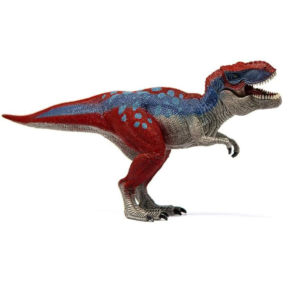 Un giocattolo a forma di dinosauro con segni rossi e blu è appoggiato su una superficie bianca. Ha mascelle aperte con denti.