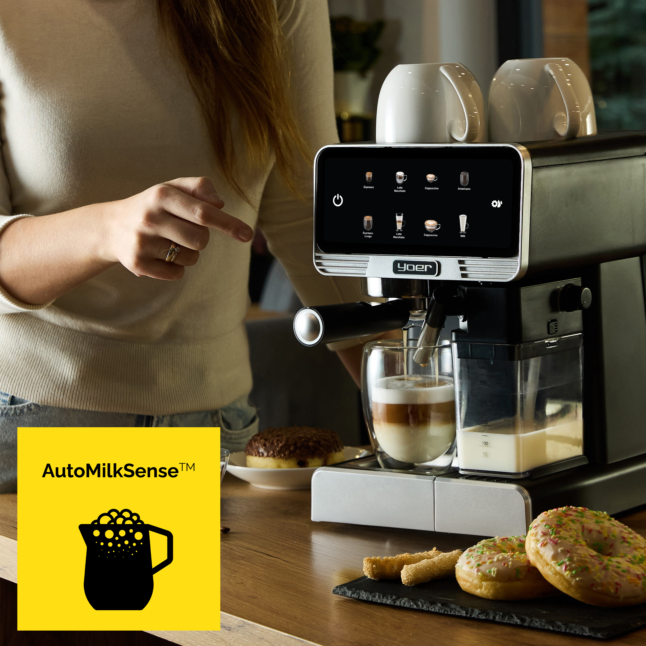 Kobieta używa ekspresu do kawy. Szklanka wypełnia się warstwową kawą. Pączki są na stole.