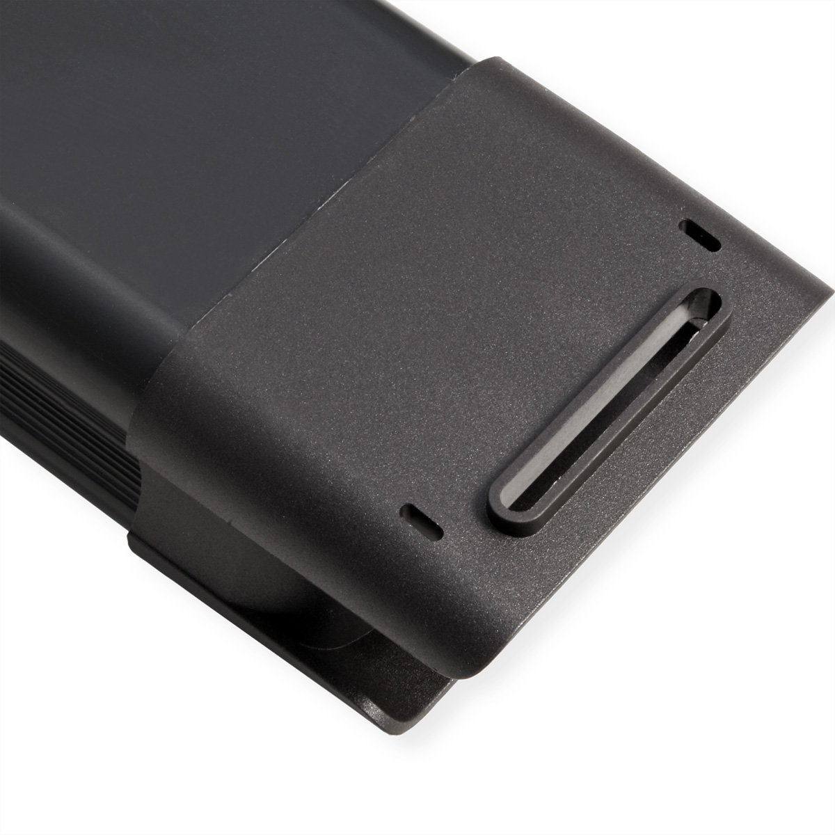 Gros plan sur un coin d'appareil noir texturé. Il comporte une fente rectangulaire et de petits trous. Le fond est blanc.