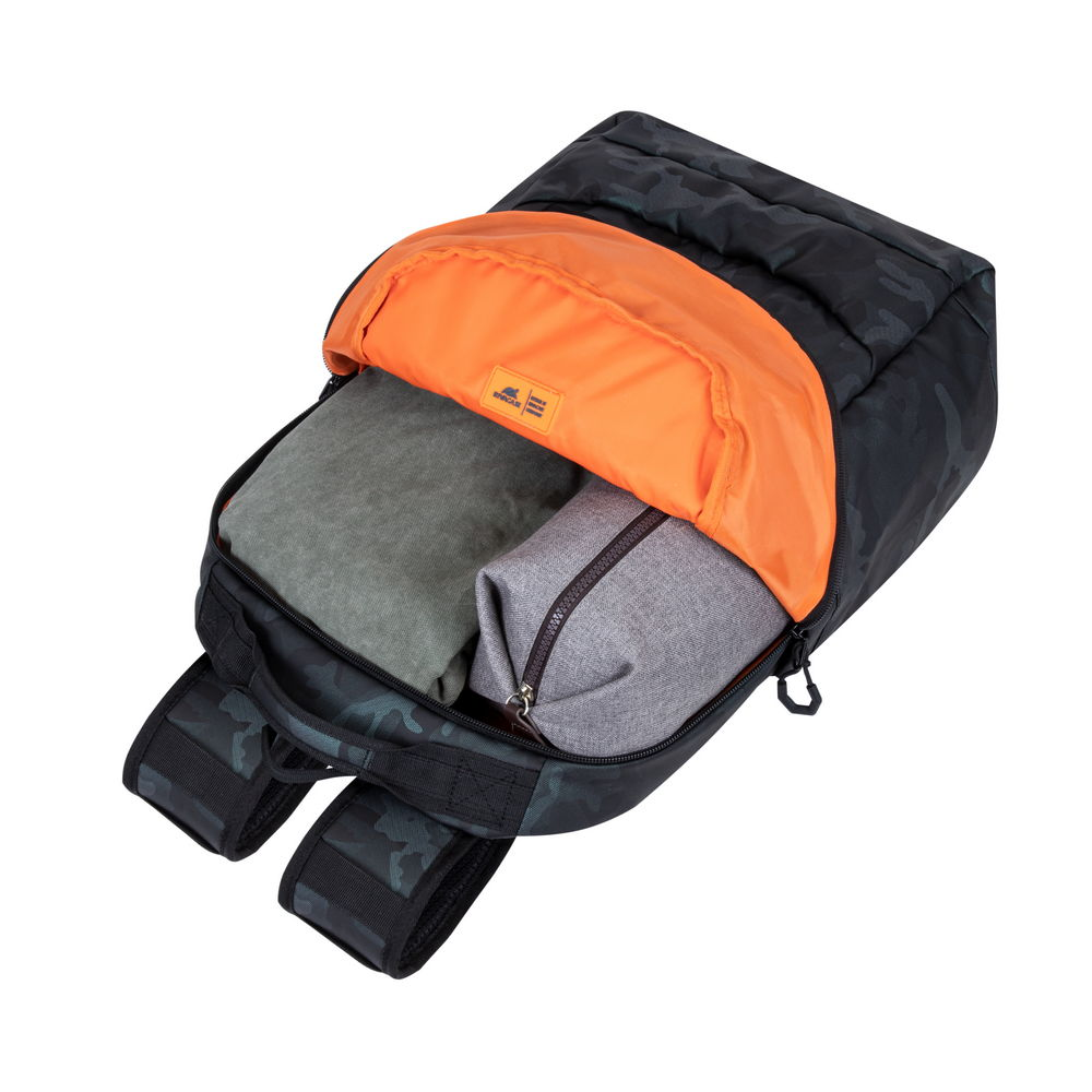 Ein schwarzer Tarnrucksack ist geöffnet und zeigt ein orangefarbenes Innenfutter, eine graue Tasche und grüne gefaltete Kleidung.