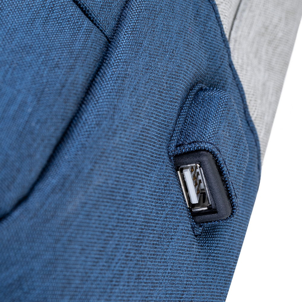 Primo piano di uno zaino blu con una porta USB. La borsa ha un tessuto strutturato e un pannello grigio. La porta USB è nera.
