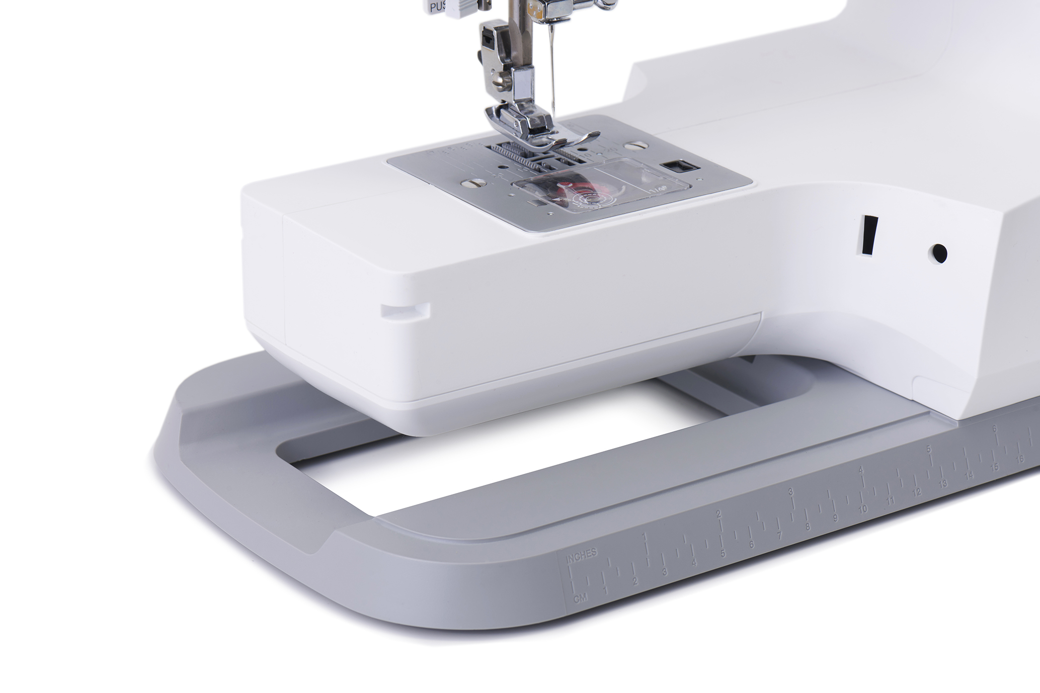 Eine weiße Nähmaschine mit einer Nadel in der unteren Position. Die Basis ist grau, und der Hintergrund ist weiß.