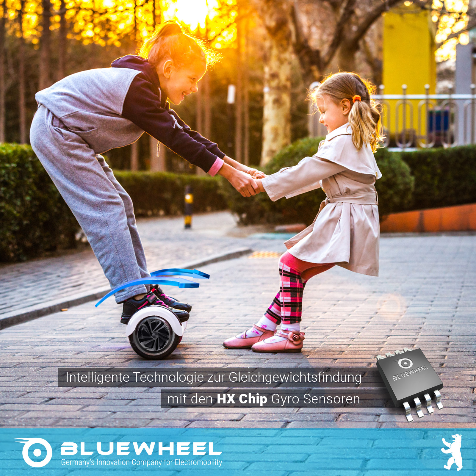 Zwei Mädchen halten sich an den Händen, eines auf einem Hoverboard. Goldenes Sonnenlicht im Hintergrund.