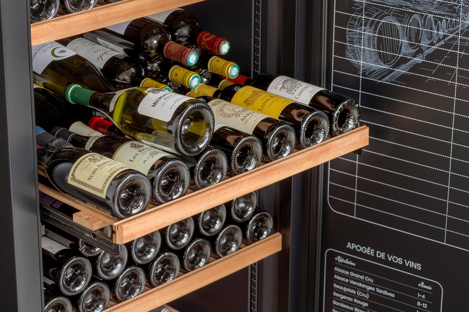 Ein Weinkühlschrank voller verschiedener Weinflaschen. Die Flaschen sind auf Holzregalen angeordnet. Rechts befindet sich eine schwarze Tafel.