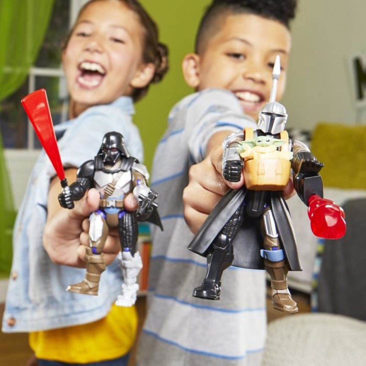 Zwei Kinder halten fröhlich Star Wars-Actionfiguren. Einer hat eine Darth-Vader-Figur mit einem roten Lichtschwert. Der andere hält eine Mandalorianer-Figur.