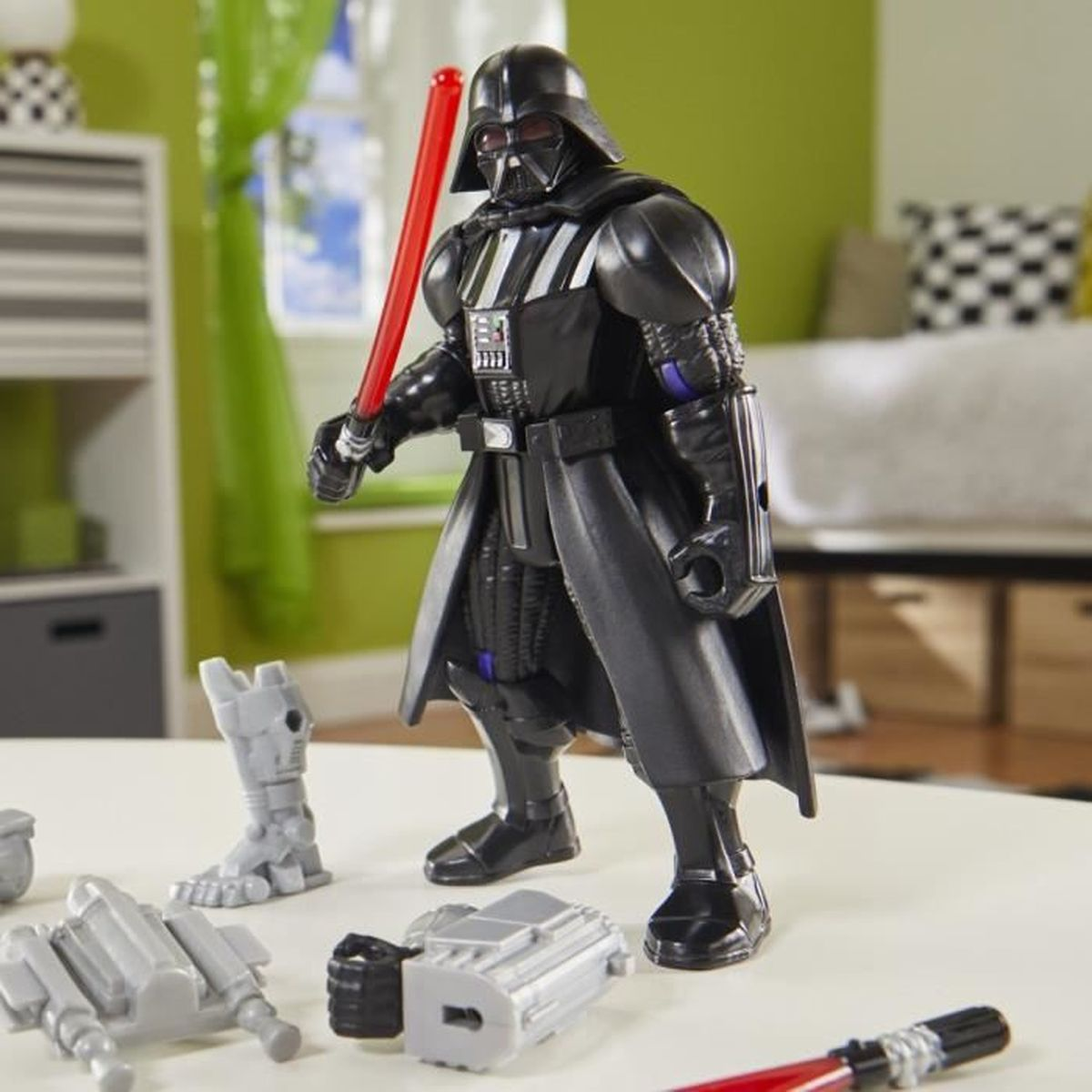 Darth Vader Actionfigur mit rotem Lichtschwert auf einem Tisch mit zerlegten Spielzeugteilen. Hintergrund umfasst Möbel.