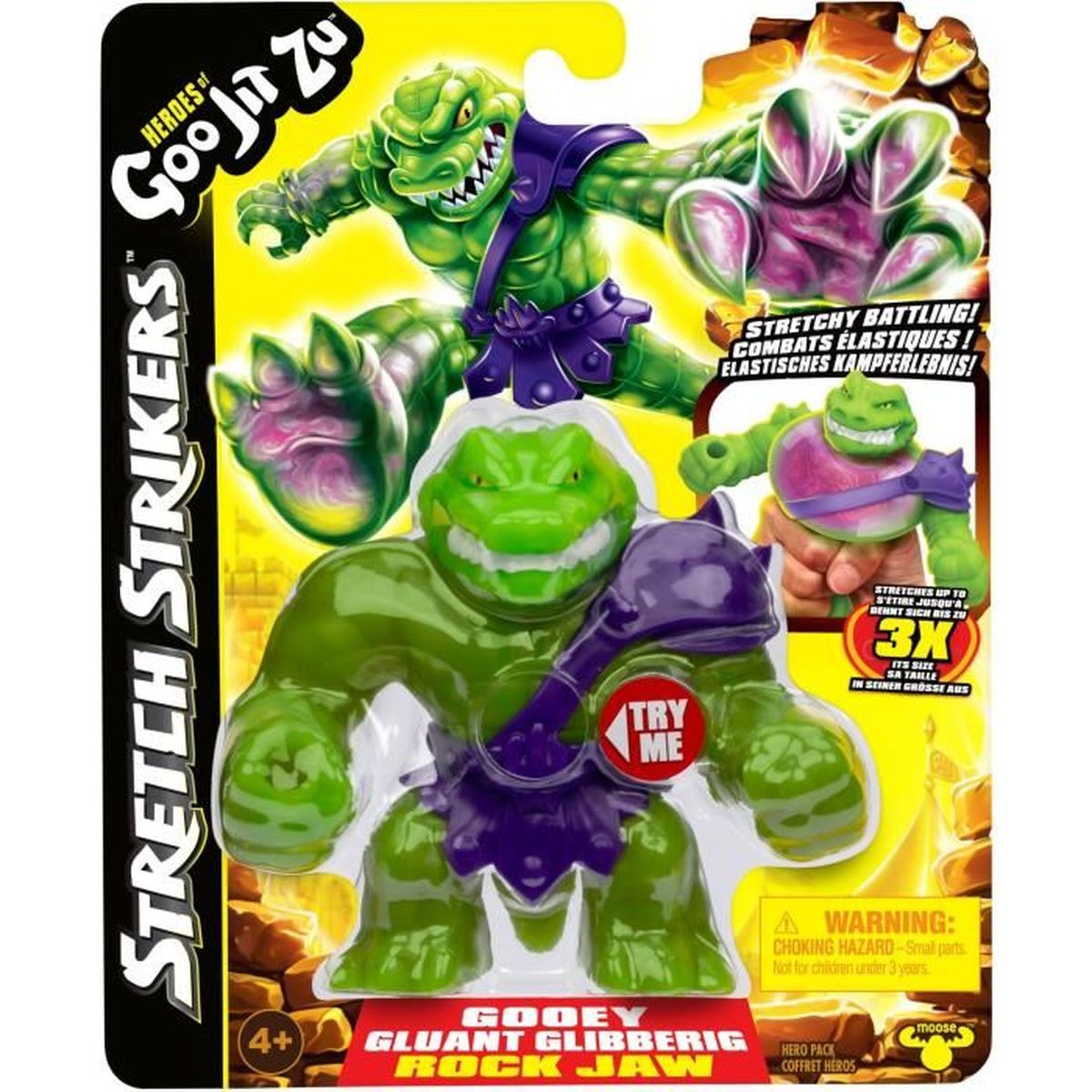 Eine Spielzeugverpackung mit grünen, lila und rosa Goo Jit Zu Figuren. Text sagt 'Stretch Strikers' und 'Goo Jit Zu'.