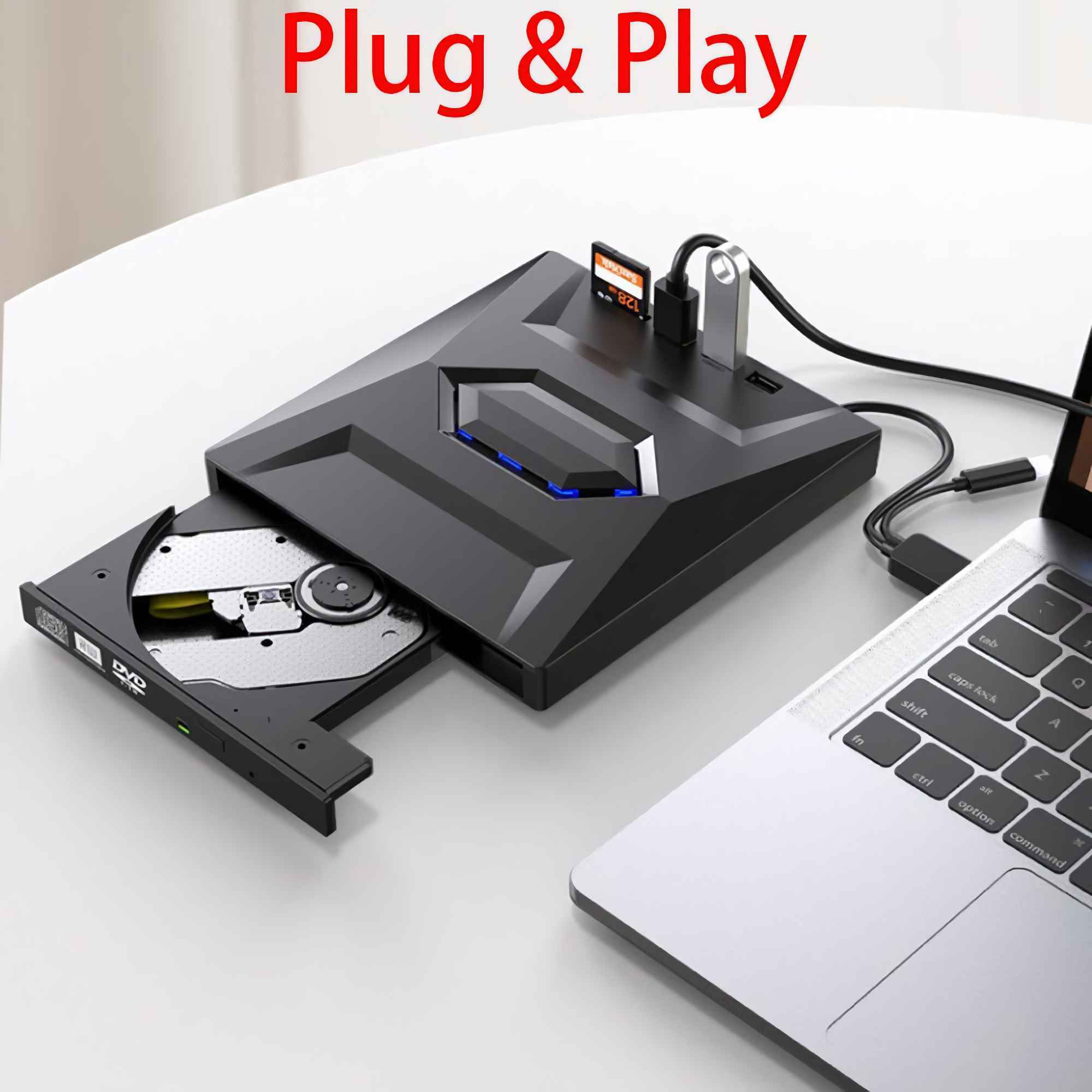 Ein schwarzer USB-Hub, ein Laptop und ein DVD-Laufwerk stehen auf einem weißen Tisch. Der Hub hat USB-Anschlüsse und einen Kartenleser.