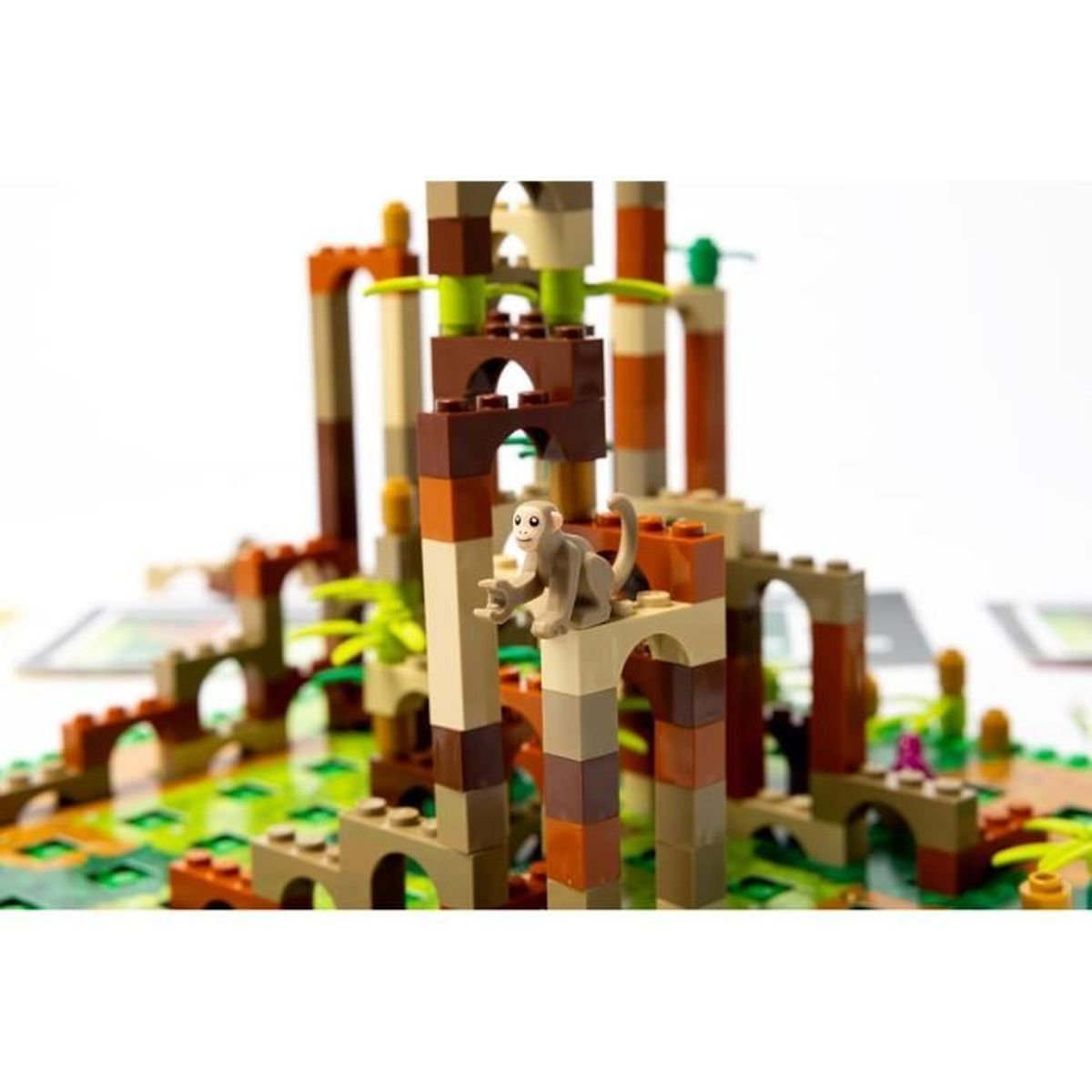 Een Lego junglescène met een apenfiguur. Gebouwen zijn gemaakt van bruine, beige en oranje blokken. Groen gebladerte is verspreid.