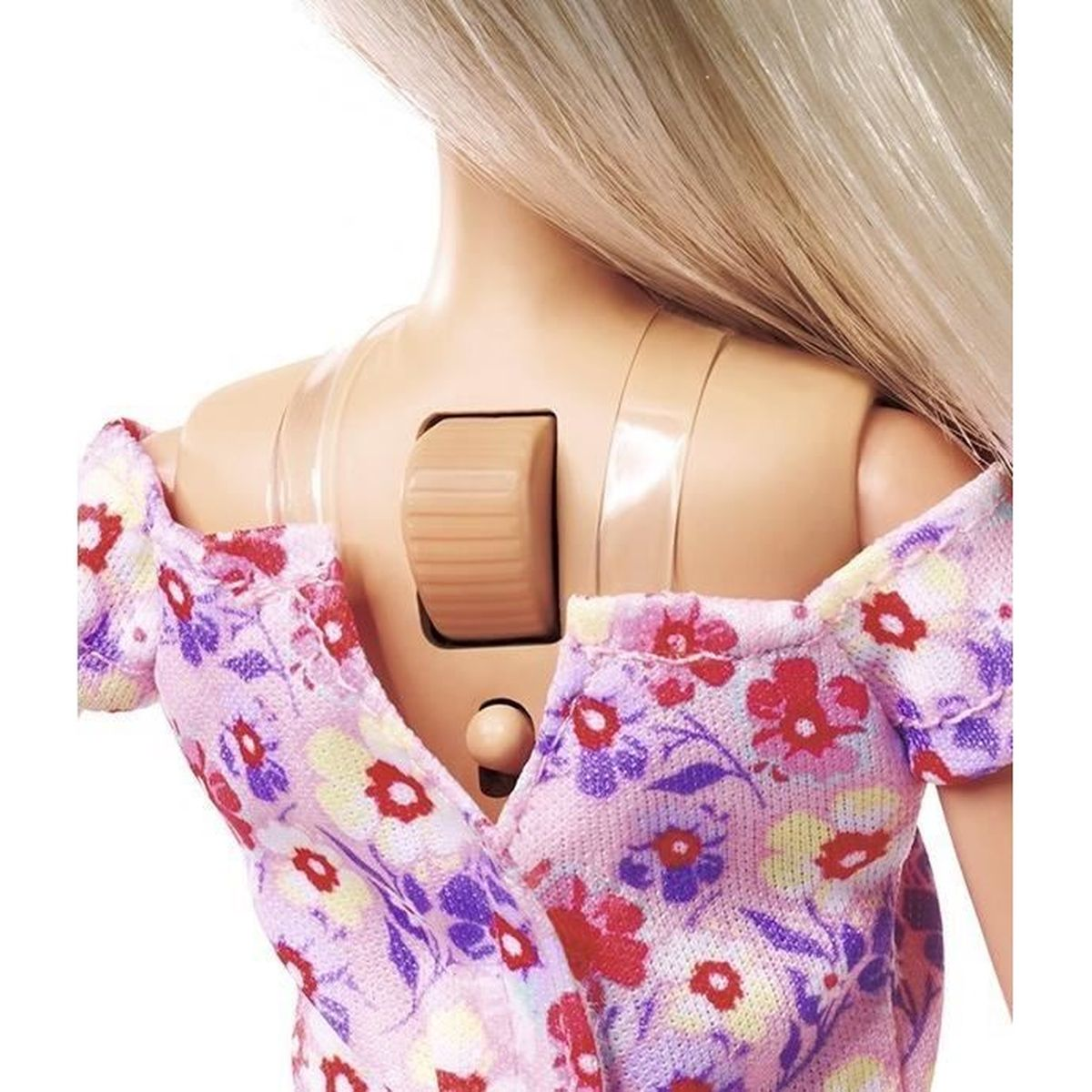 Rückseite einer Puppe mit blondem Haar, die ein Blumenkleid trägt. Auf dem Rücken befindet sich ein braunes Ziffernblatt. Das Kleid hat rote, gelbe und lila Blumen.