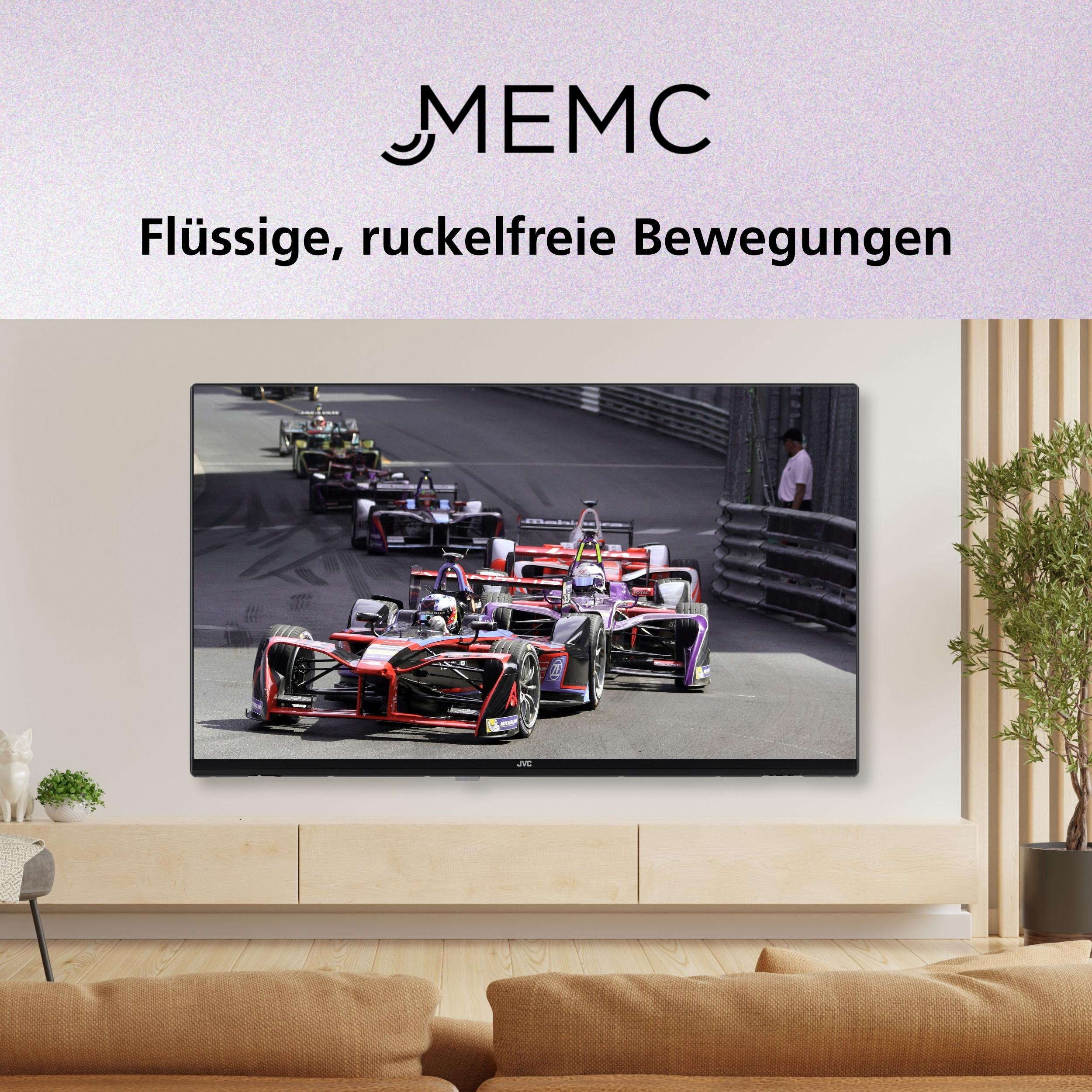 Der Fernseher zeigt Rennwagen. Der Fernseher ist auf einem hellen Holzschrank montiert. Der Hintergrund ist eine Wand und eine Pflanze.
