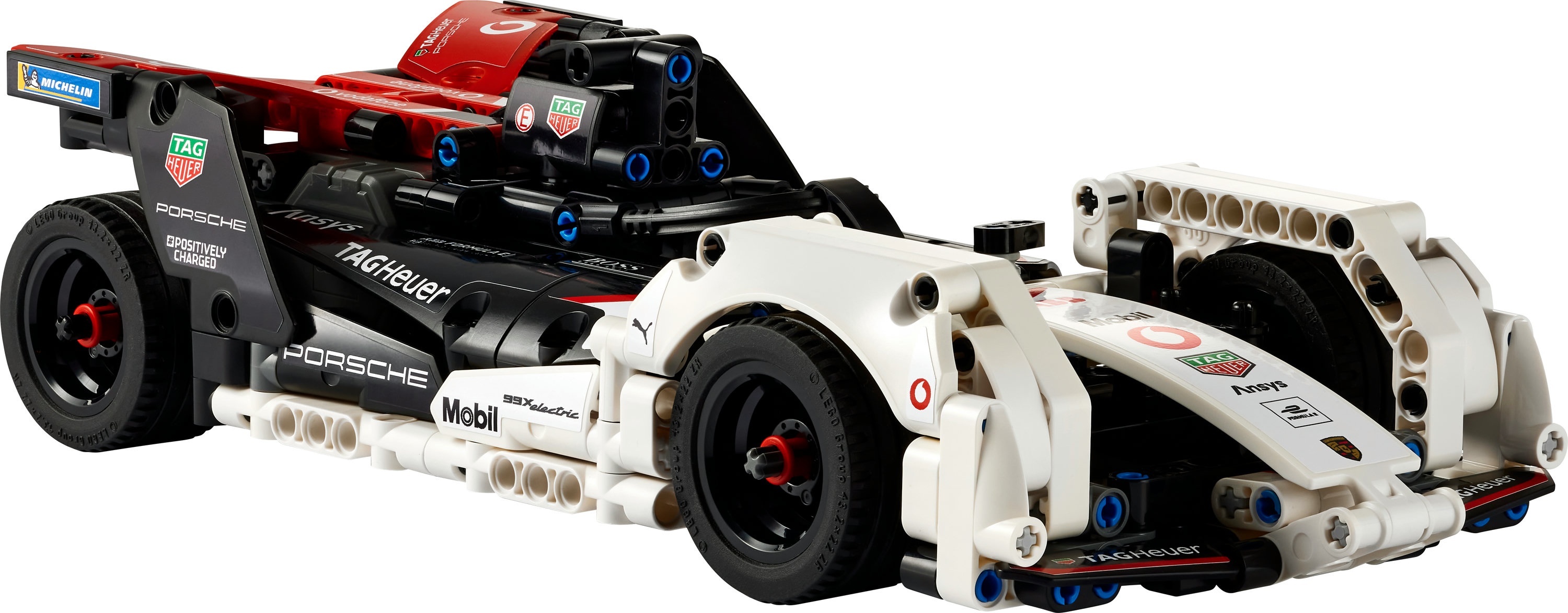 Ein LEGO Technic Porsche Rennwagenmodell. Das Auto ist weiß, schwarz und rot. Das Auto hat Sponsorenlogos wie TAG Heuer und Michelin.