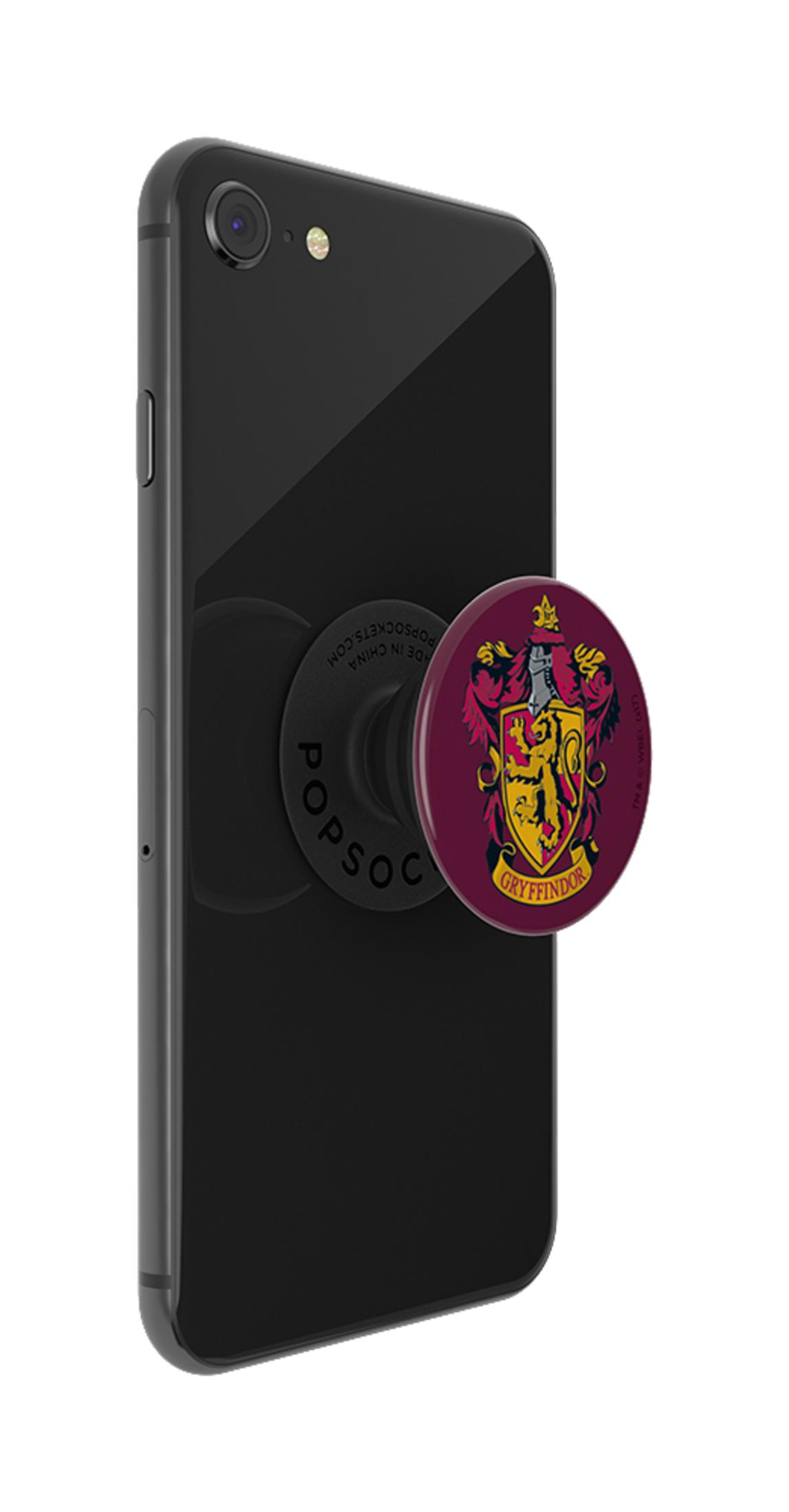Un teléfono inteligente negro con un PopSocket de Gryffindor adjunto. El PopSocket tiene el escudo de la casa, un diseño rojo y dorado.