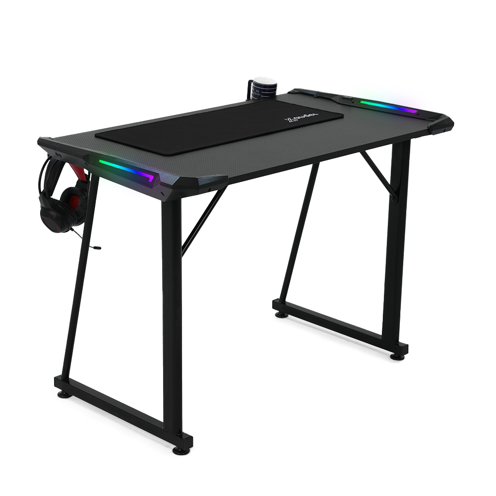 Ein schwarzer Gaming-Schreibtisch mit Mauspad, Headset und einer Tasse. Der Schreibtisch hat LED-Lichter an den Kanten und schwarze Beine.