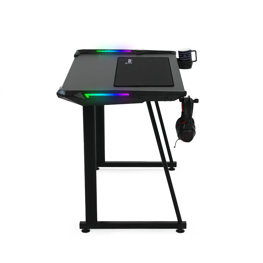 Ein Gaming-Schreibtisch mit schwarzer Oberfläche, RGB-Beleuchtung, Mauspad, Becher und Kopfhörern. Der Hintergrund ist weiß.