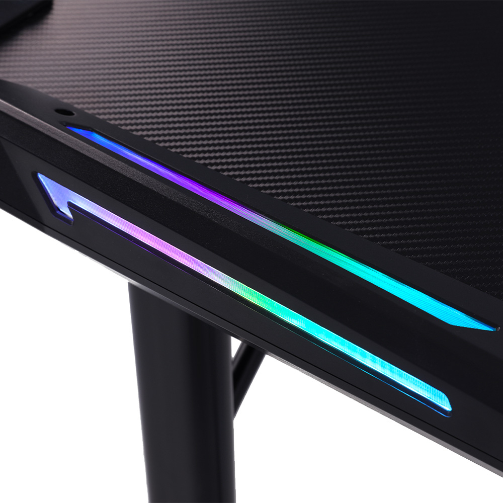 Nahaufnahme eines schwarzen Gaming-Schreibtischs mit mehrfarbigen LED-Leuchten. Der Schreibtisch hat eine Kohlefaserstruktur und ein pfeilförmiges Design.