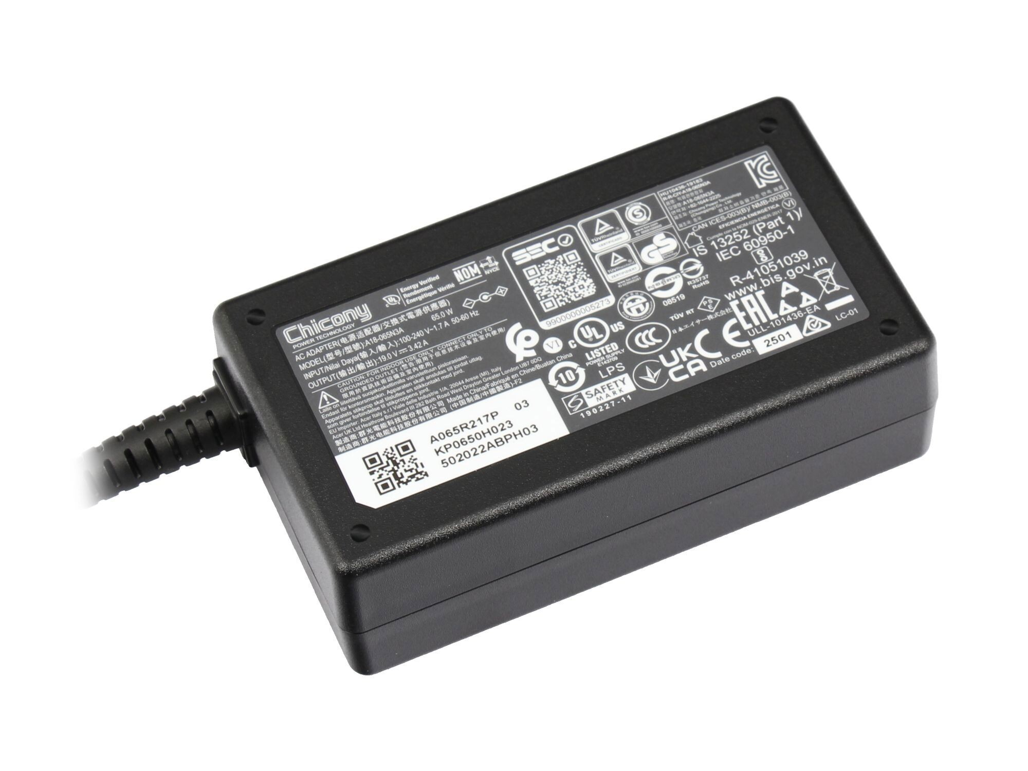 Schwarzes Netzteil mit Etiketten und angeschlossenem Kabel. Der Adapter hat verschiedene Zertifizierungen.